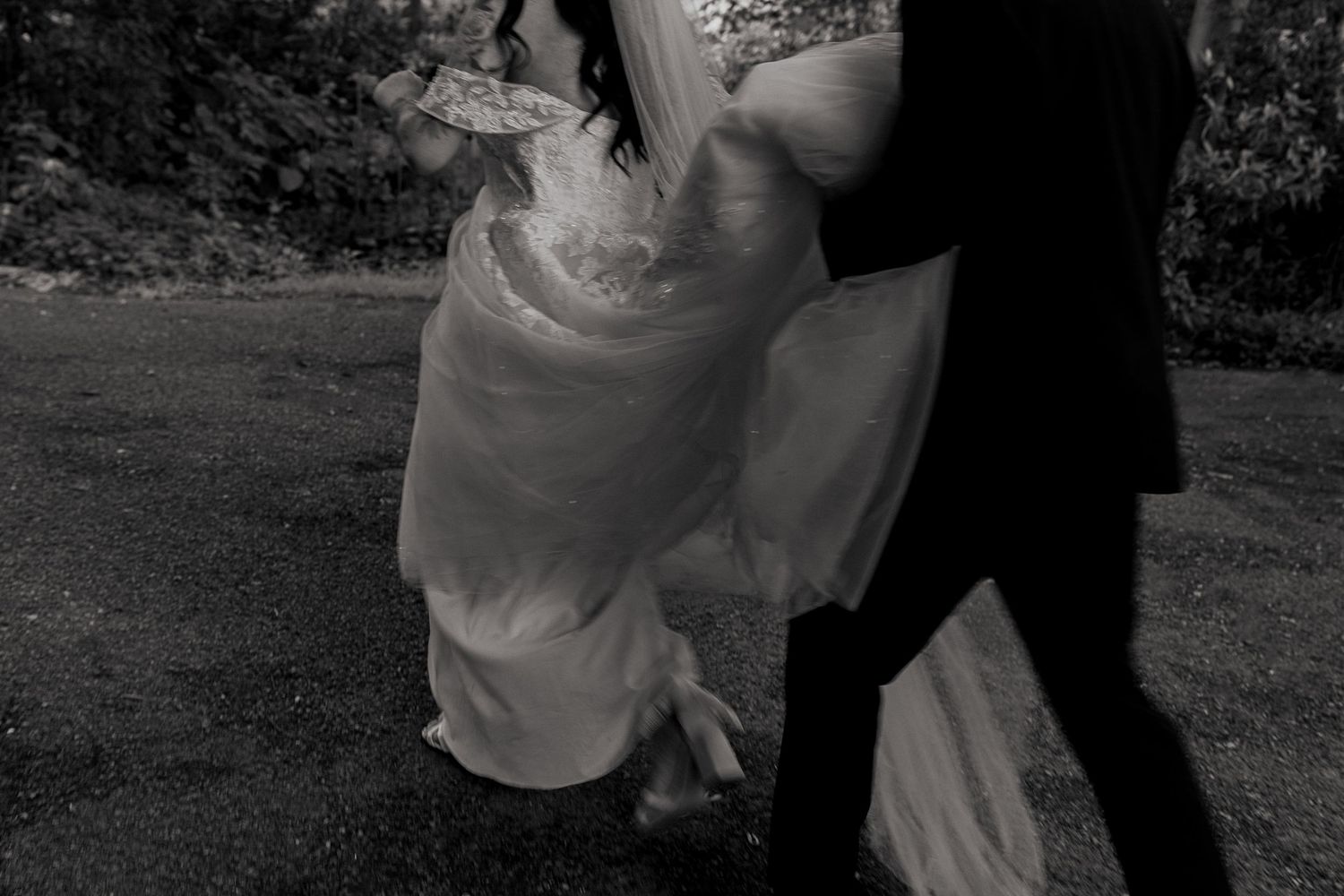 groom holding brides dress