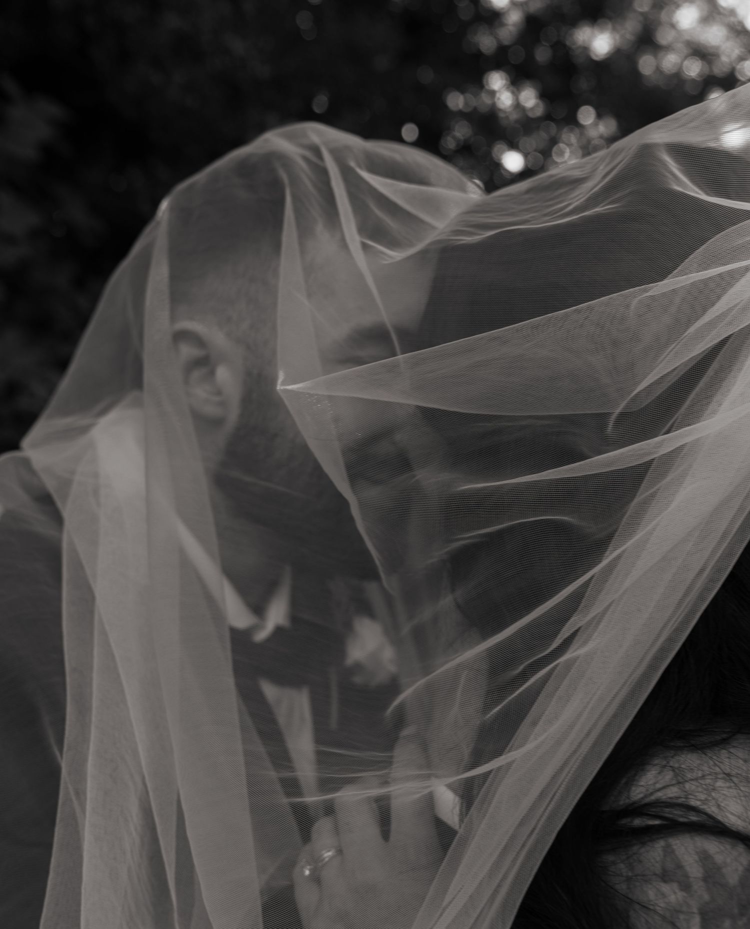 bride and groom under vail