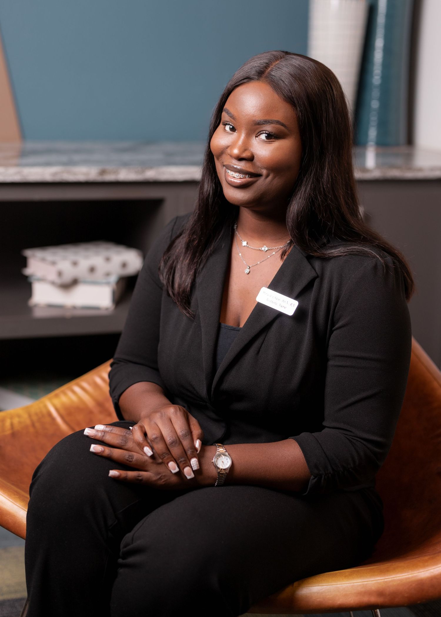 Business professional seated in leather chair during corporate photoshoot.