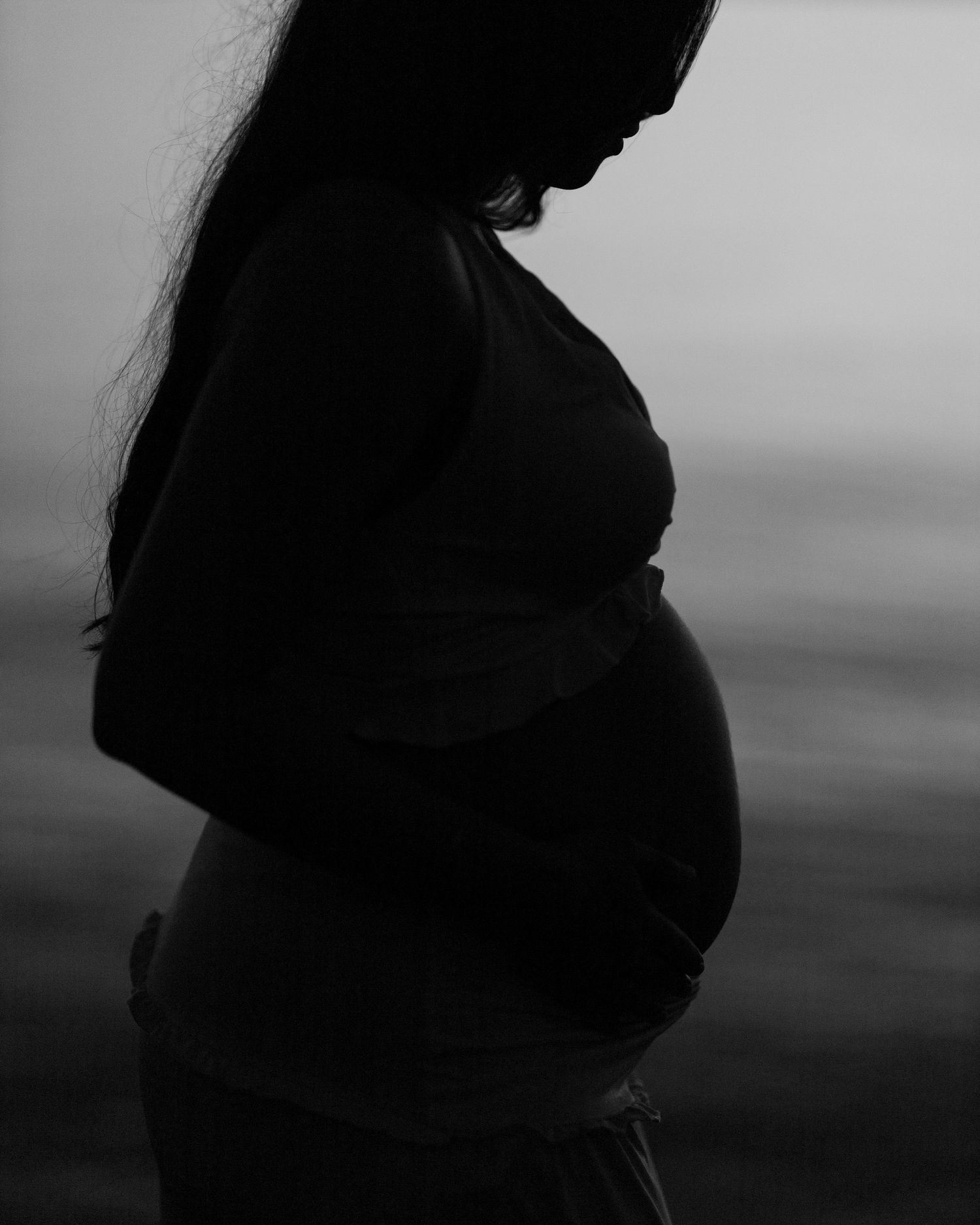 Dramatic black and white profile silhouette against moody sky.