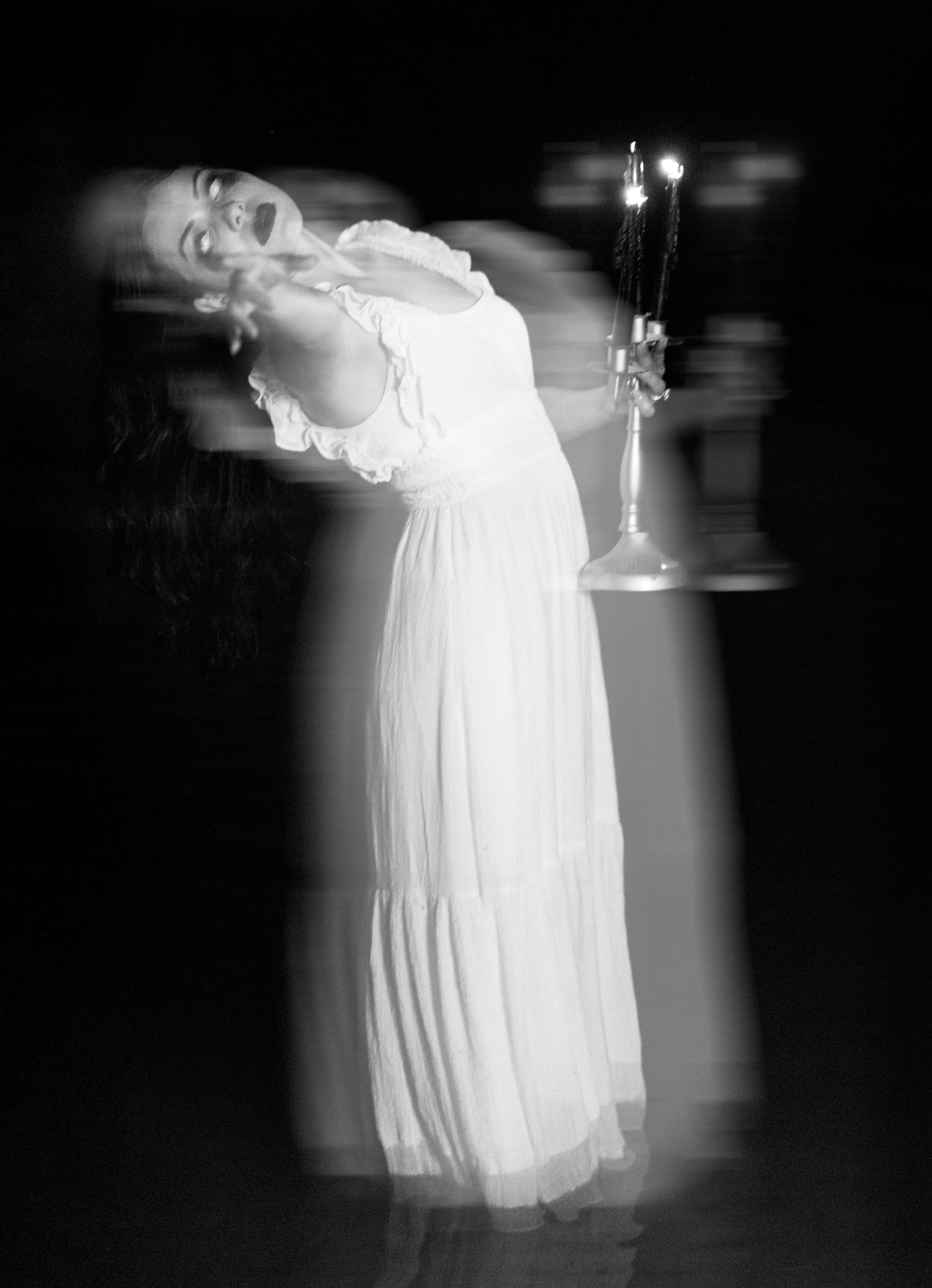 Artistic black and white sequence showing a figure in a flowing white dress creating ethereal motion blur effects.