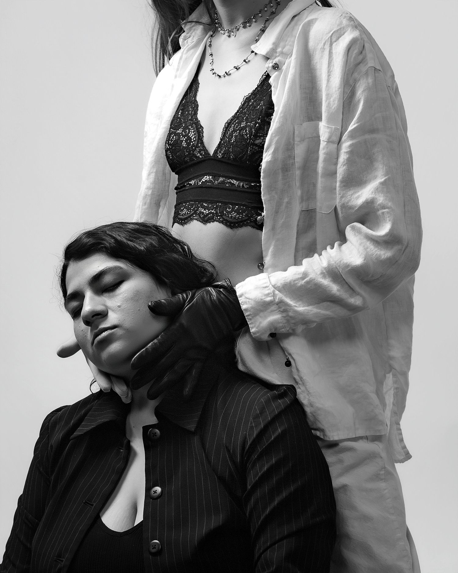 A black and white fashion photo series showing a person in dark clothing posing with someone in white attire.