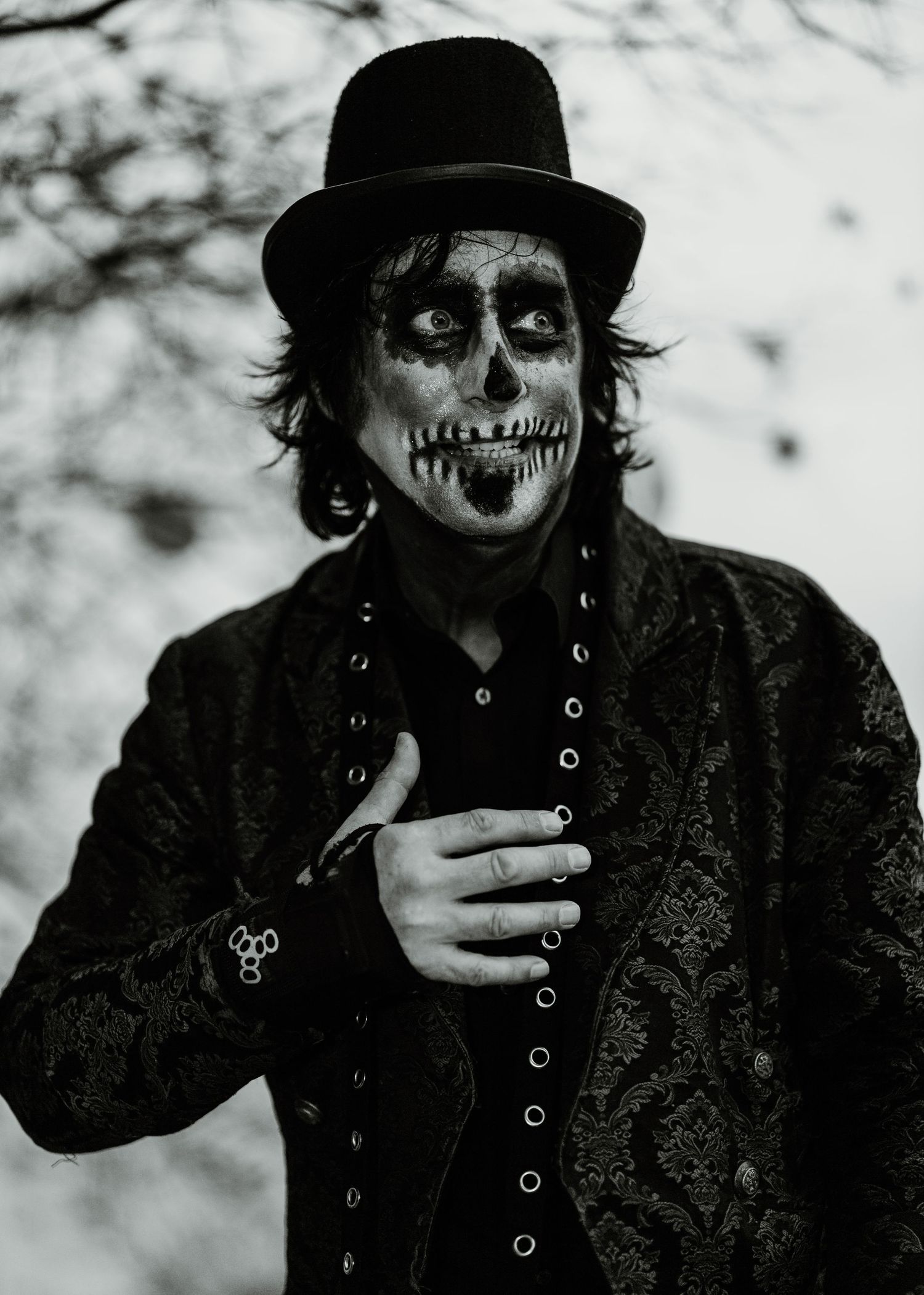 A spooky black and white photo sequence showing a figure in dark clothing with skull-like face paint making dramatic expressions.
