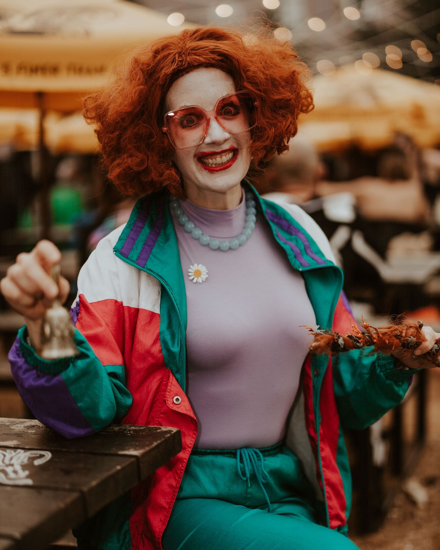 Colorful 90s style windbreaker jacket outfit with bright red hair and sunglasses in retro aesthetic photoshoot.