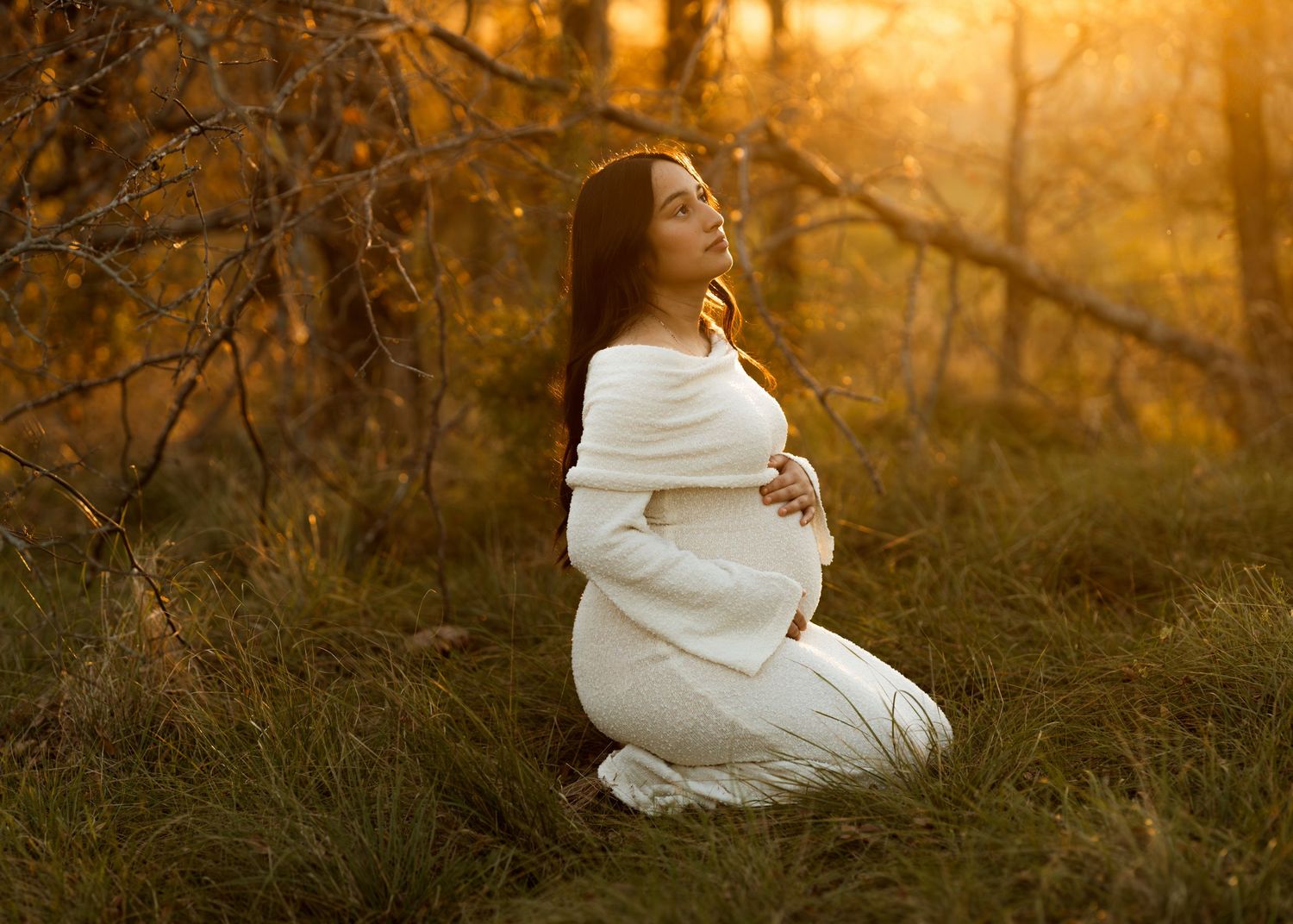 Artistic sunset portrait with figure in white dress amid golden grasses.