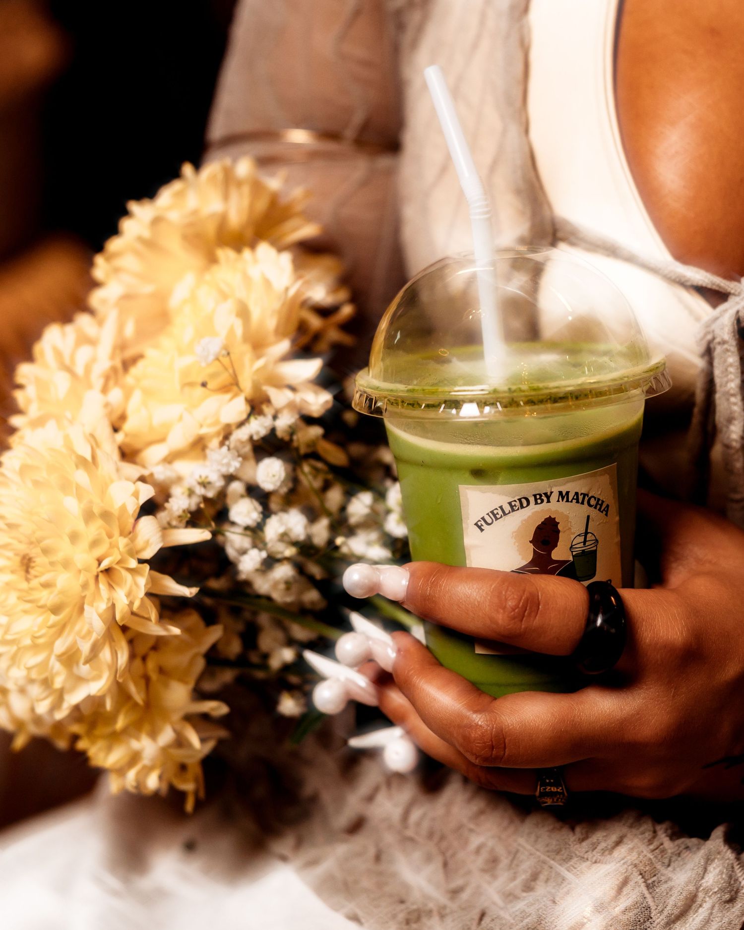 Artistic shots of hands holding a green candle with yellow and white flowers.