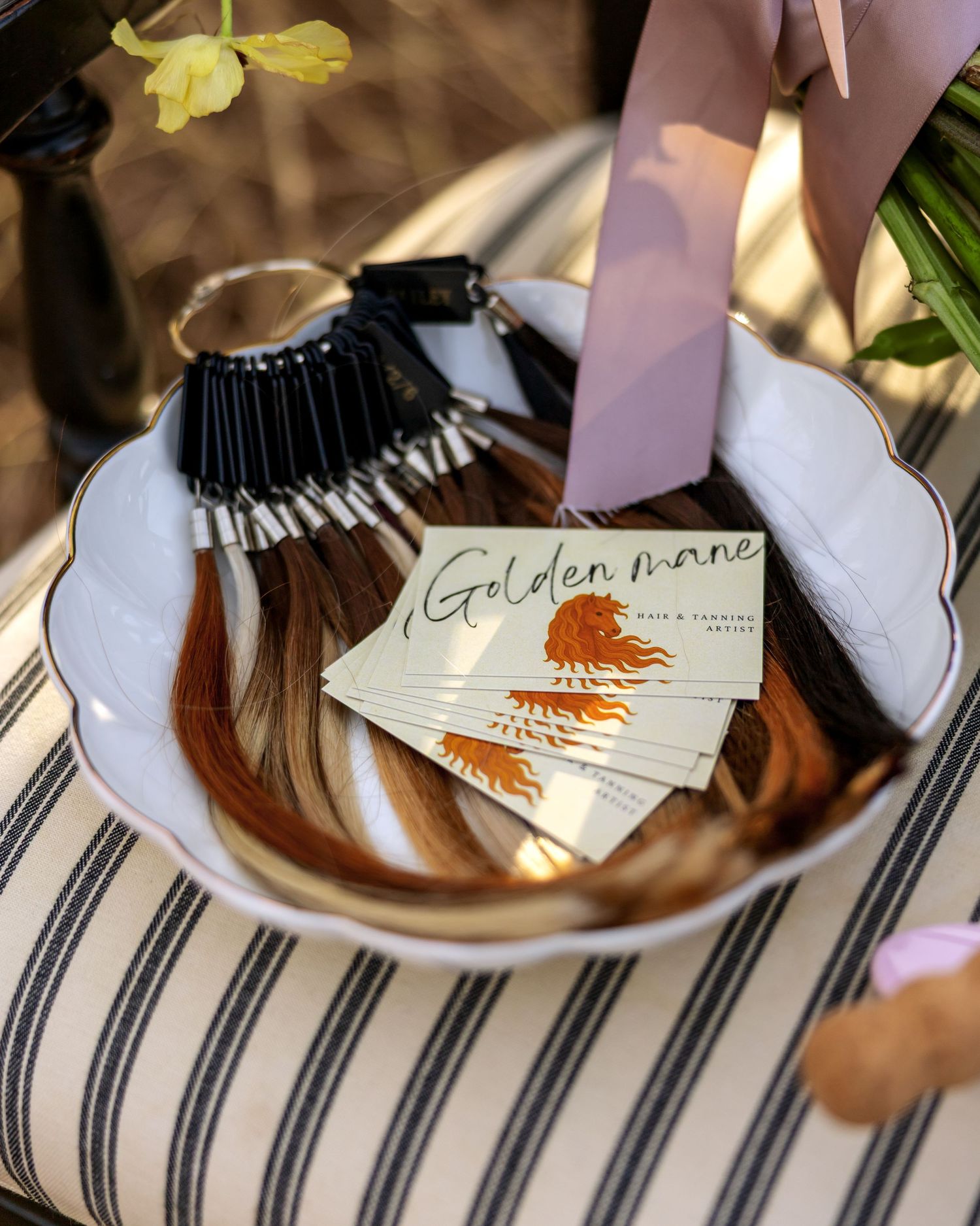 Golden hour business cards being arranged on a striped cloth surface.