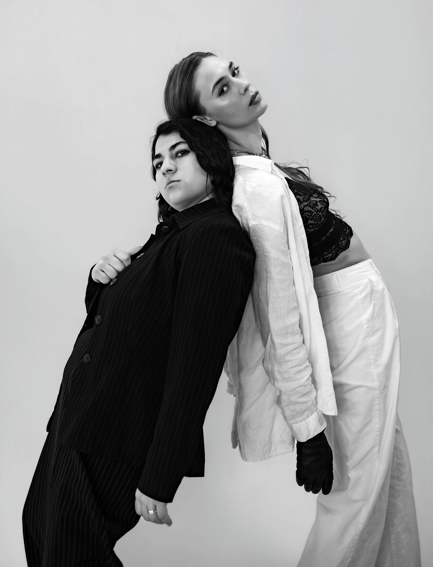 Artistic black and white fashion portraits showing dynamic poses in contrasting black and white outfits.