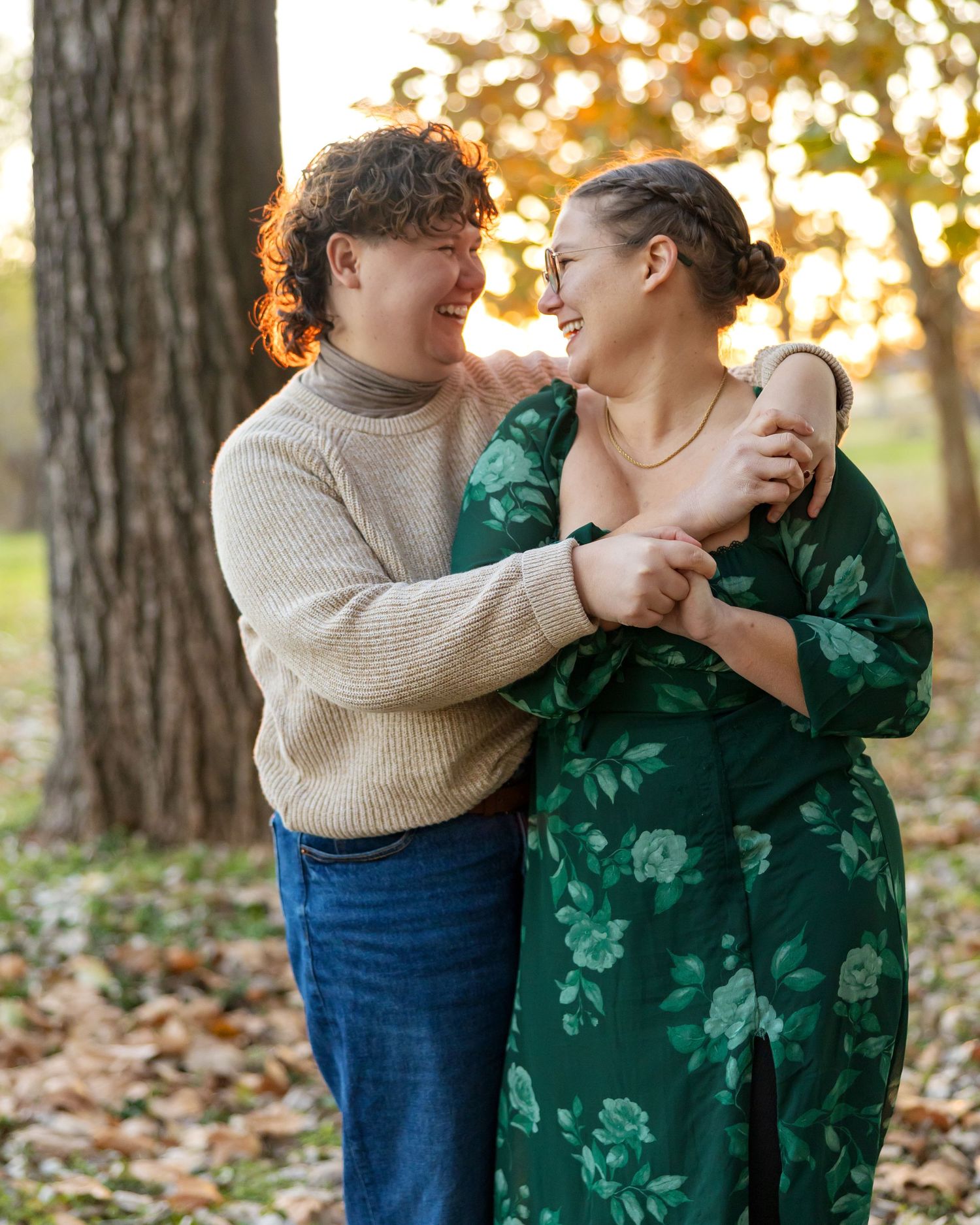 Couple in casual autumn wear sharing intimate moment among fallen leaves.