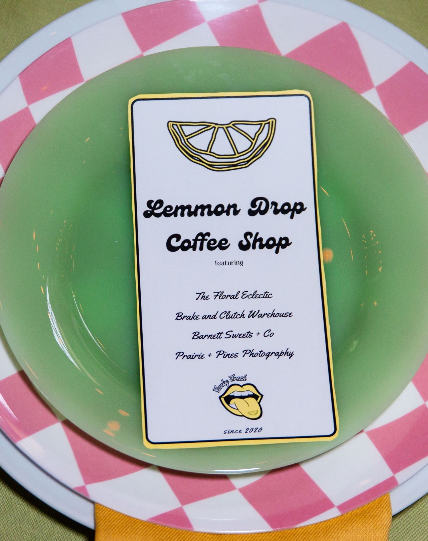 Green plates with pink checkered pattern and Lemmon Drop Coffee Shop branding.