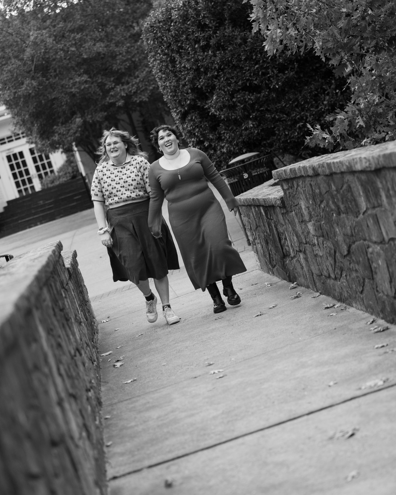 Black and white image of people walking along a stone pathway.