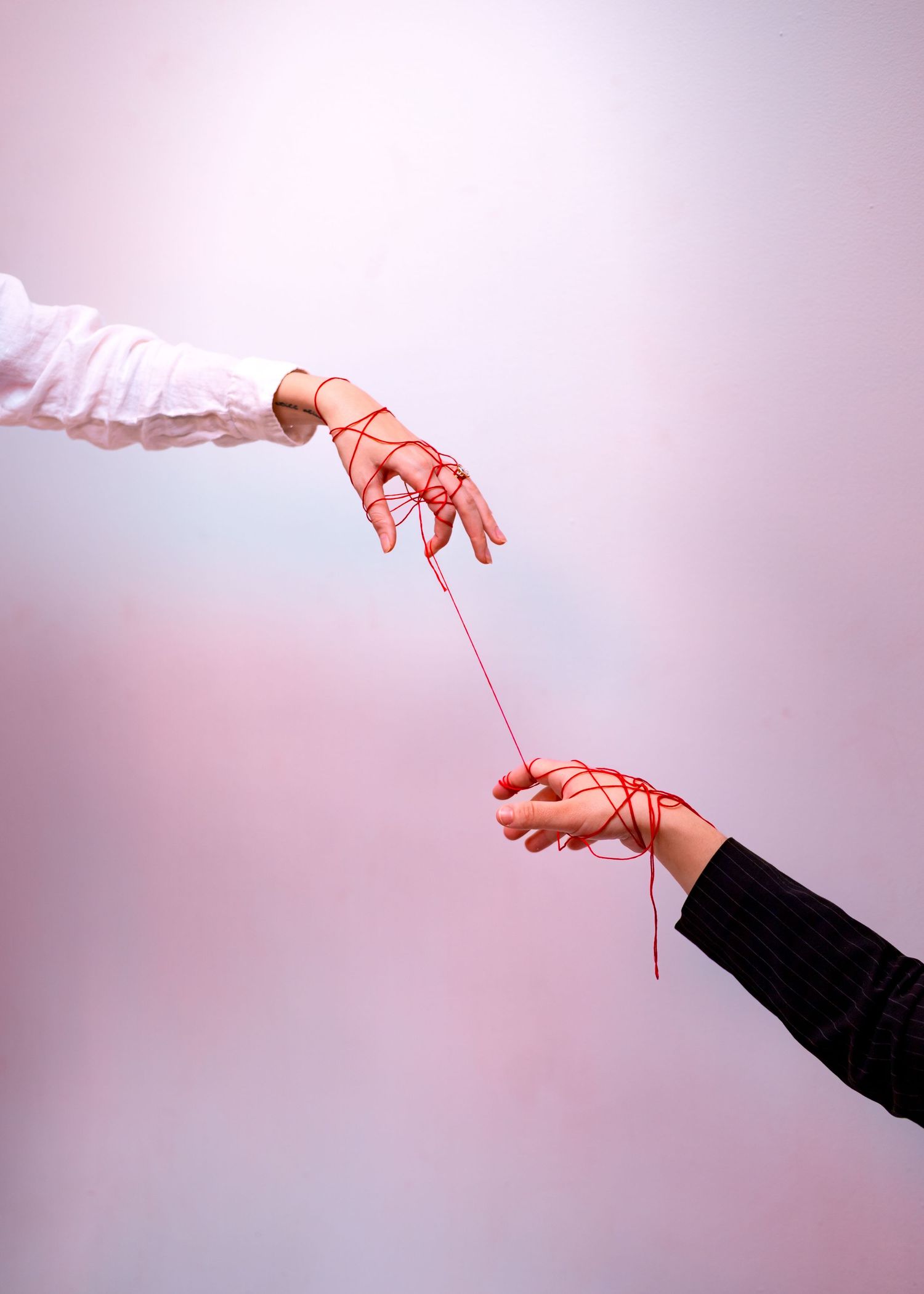 A series of hands connected by red strings against a light background illustrates the concept of connection and manipulation.