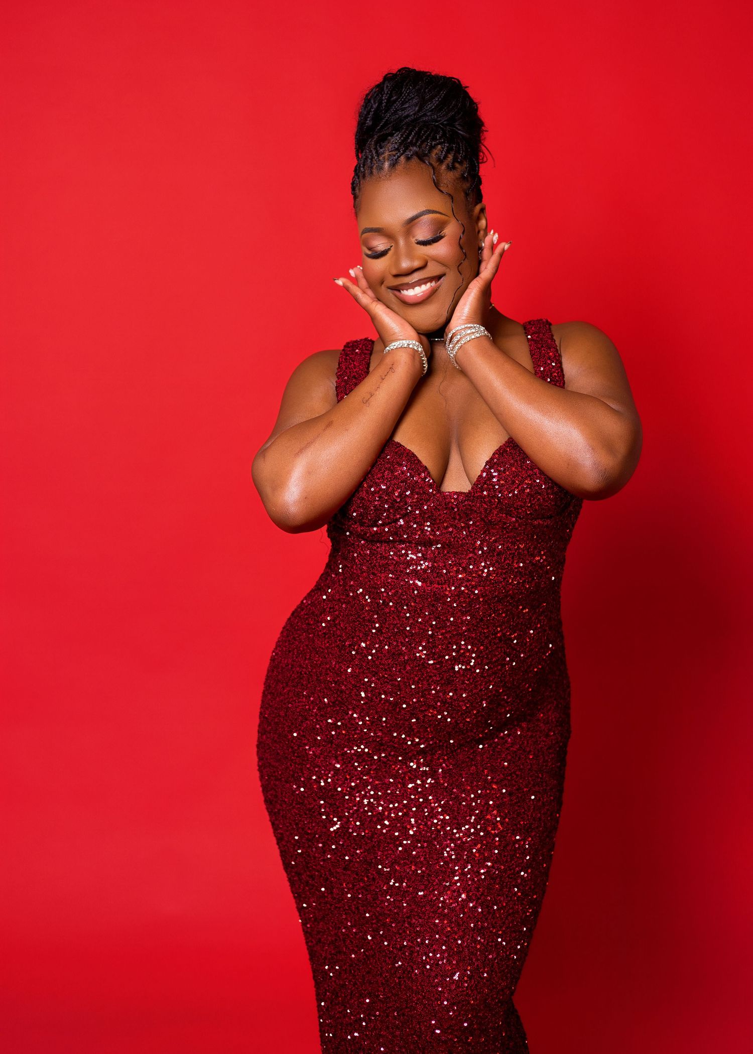 Fashion photoshoot against vibrant red backdrop featuring glamorous sequined gown.