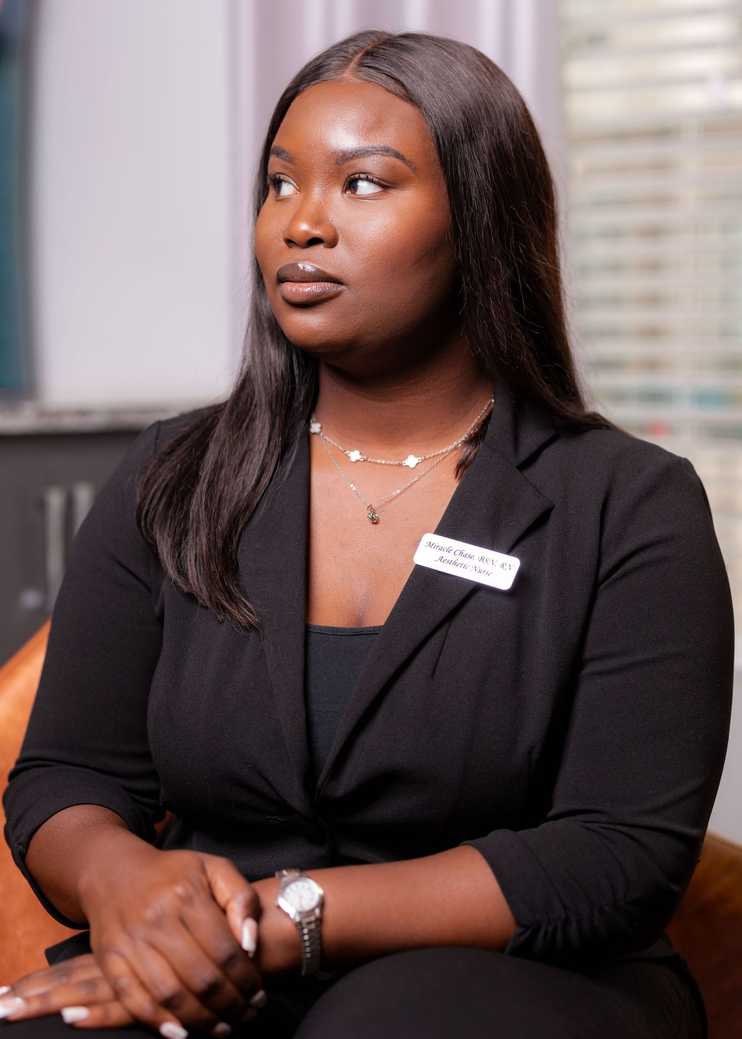 Professional portrait in business attire seated in office setting.
