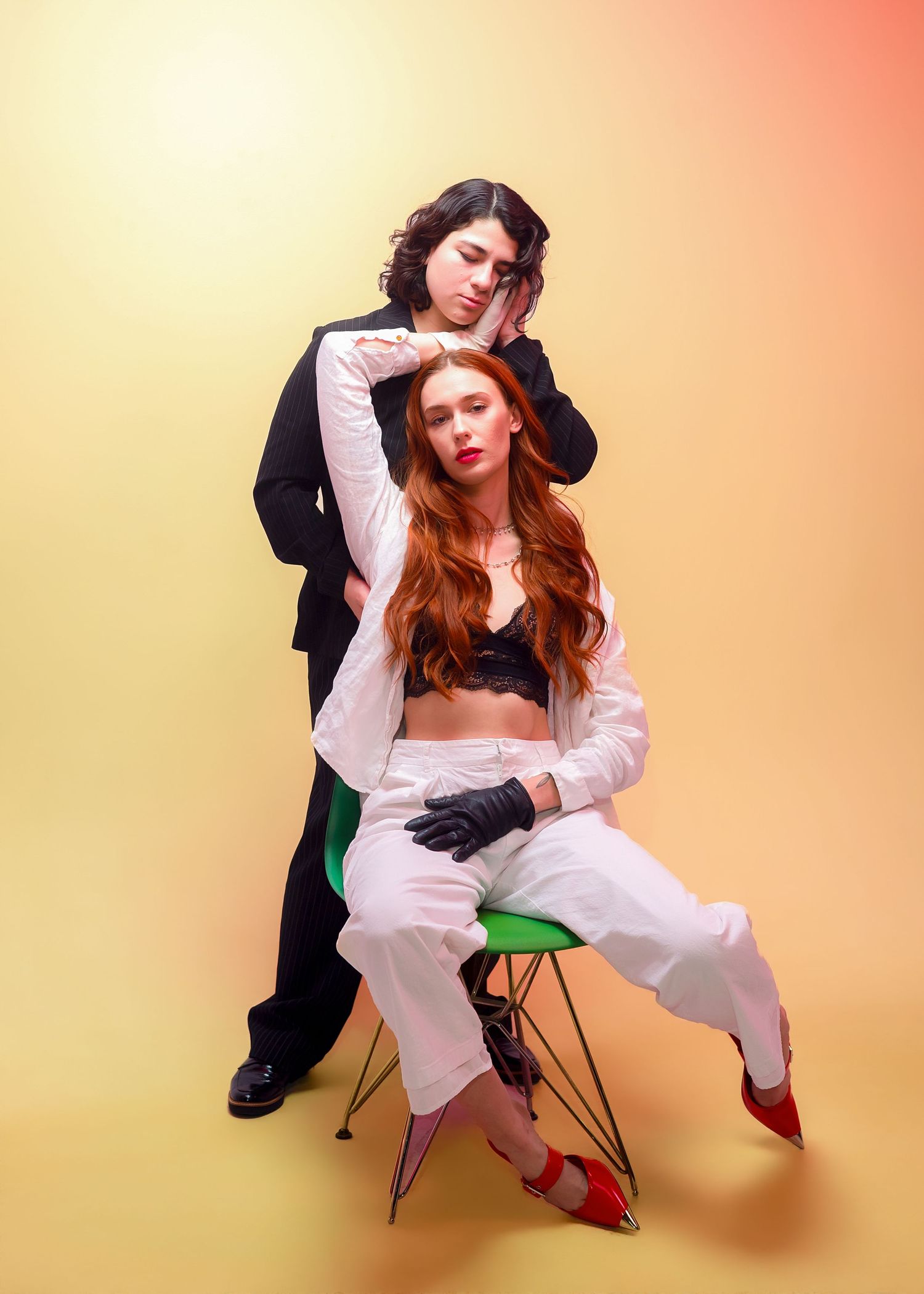 Fashion model poses in white dress and red heels against peach background in artistic photo series.