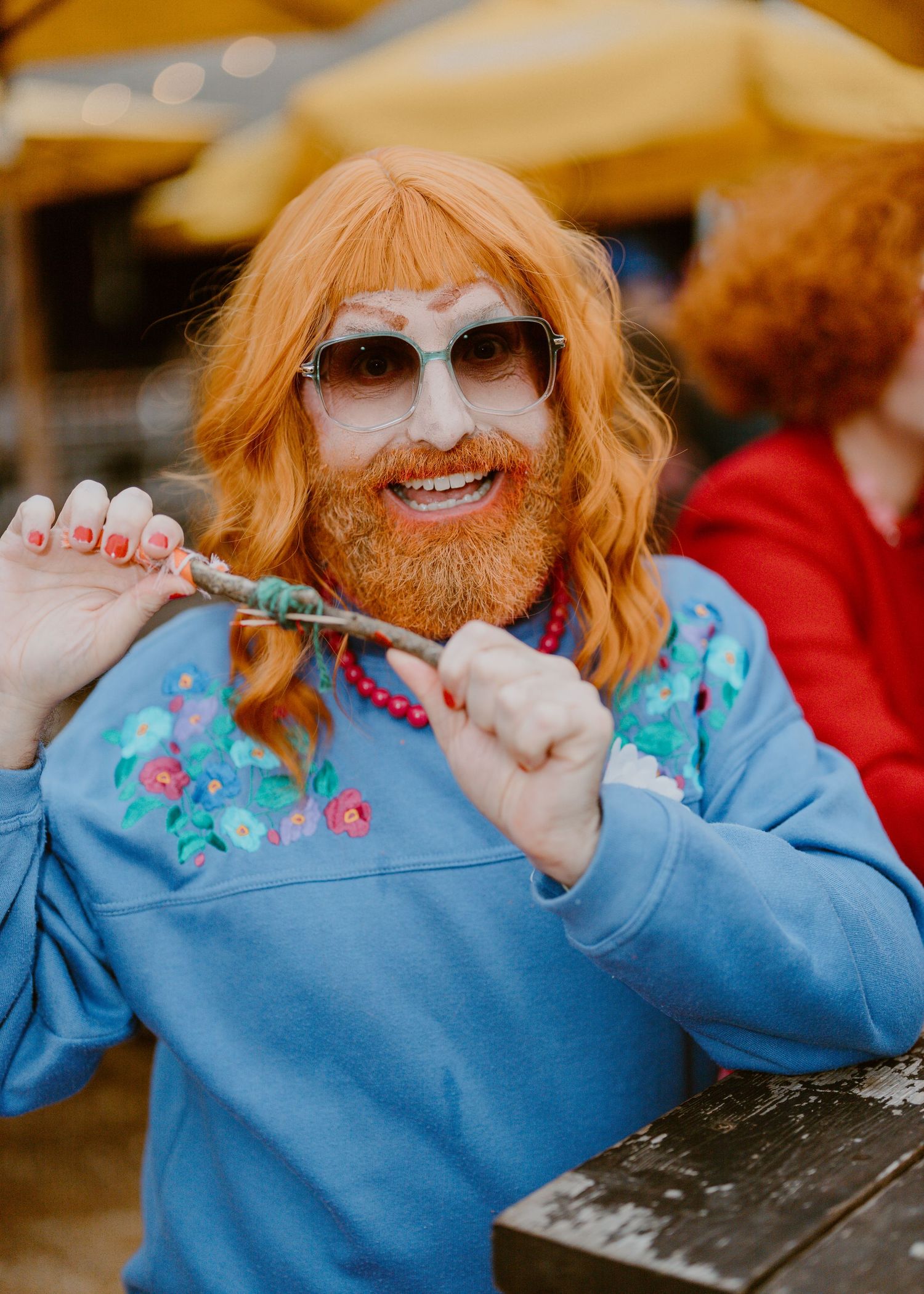 Person in light blue sweater with orange hair smiling and posing in a sequence of playful photos.