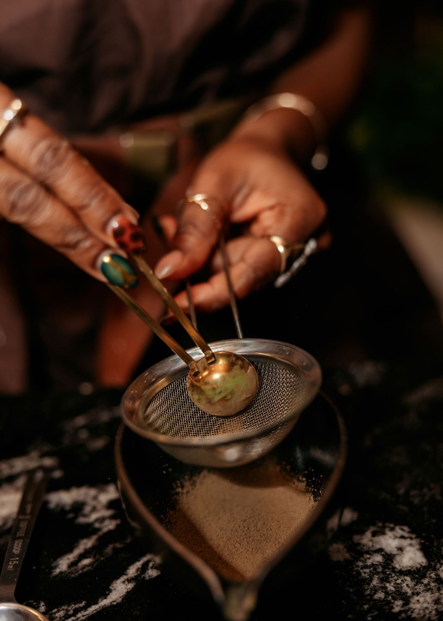 Close-up of hands lighting a candle with a match on a textured surface.