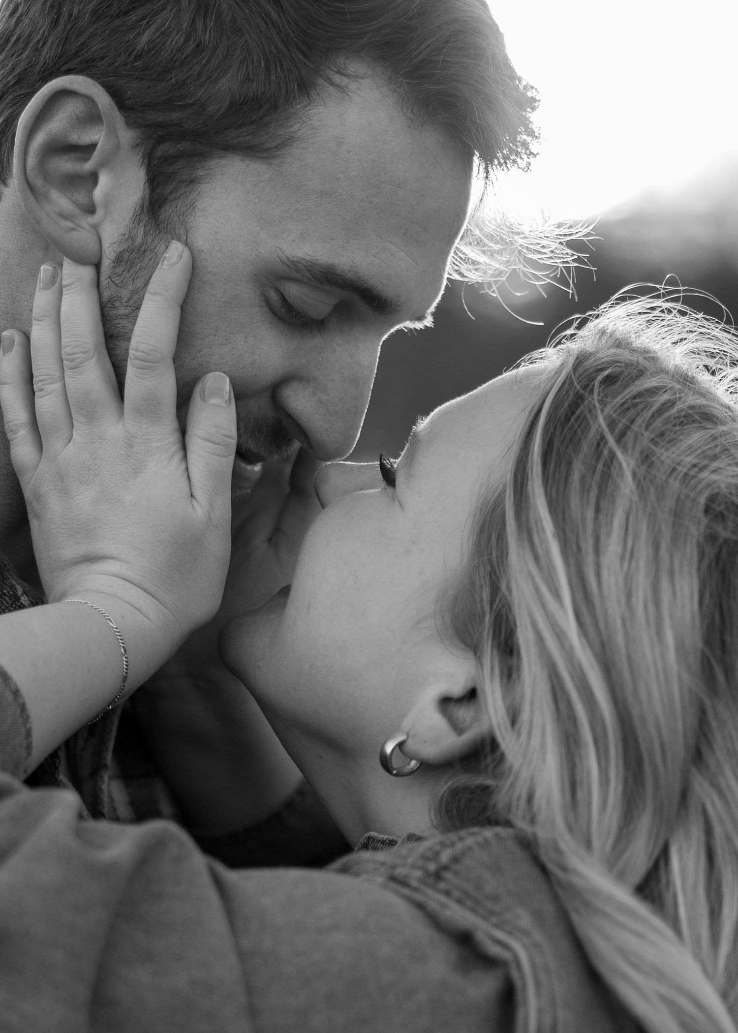 Romantic couple embracing and sharing intimate moments in black and white photography.