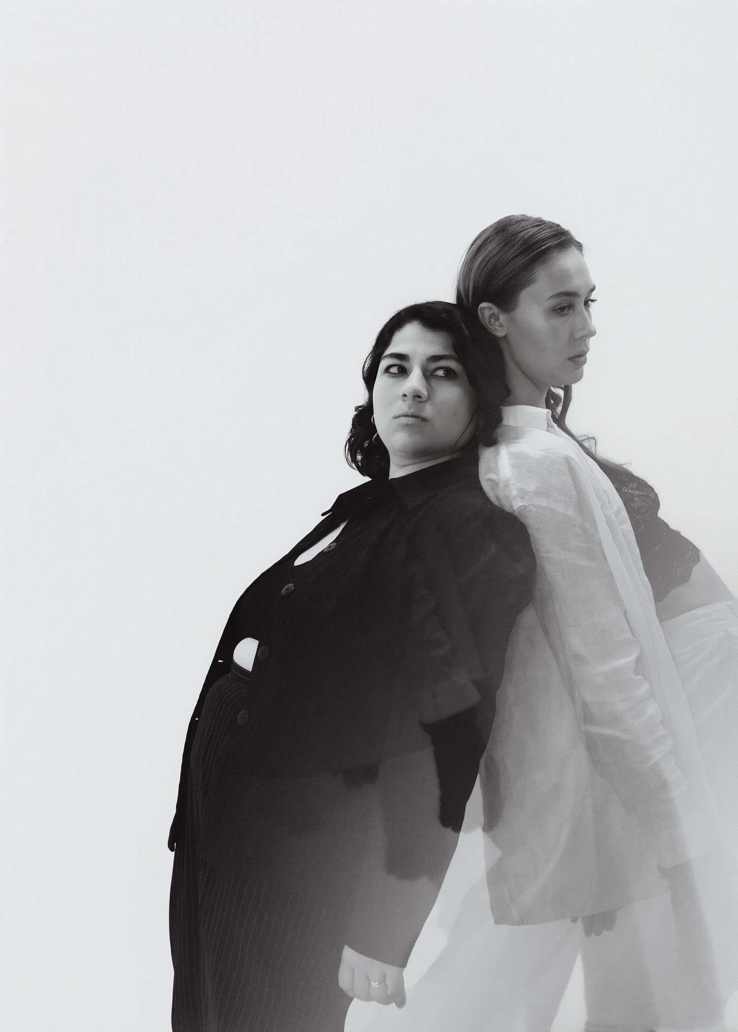 Black and white minimalist portrait series showing two figures in contrasting black and white outfits.