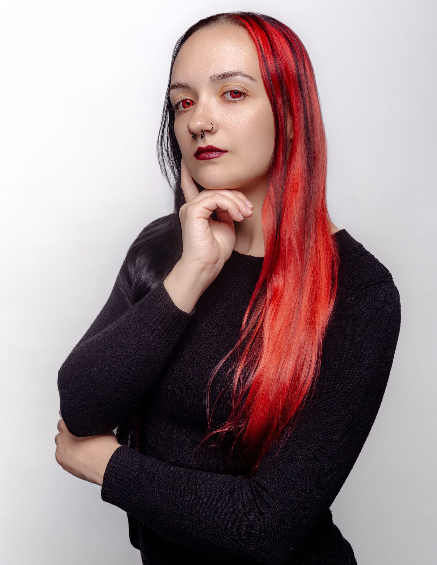 Artistic portraits showing person in black turtleneck with red hair striking contemplative poses against white wall.