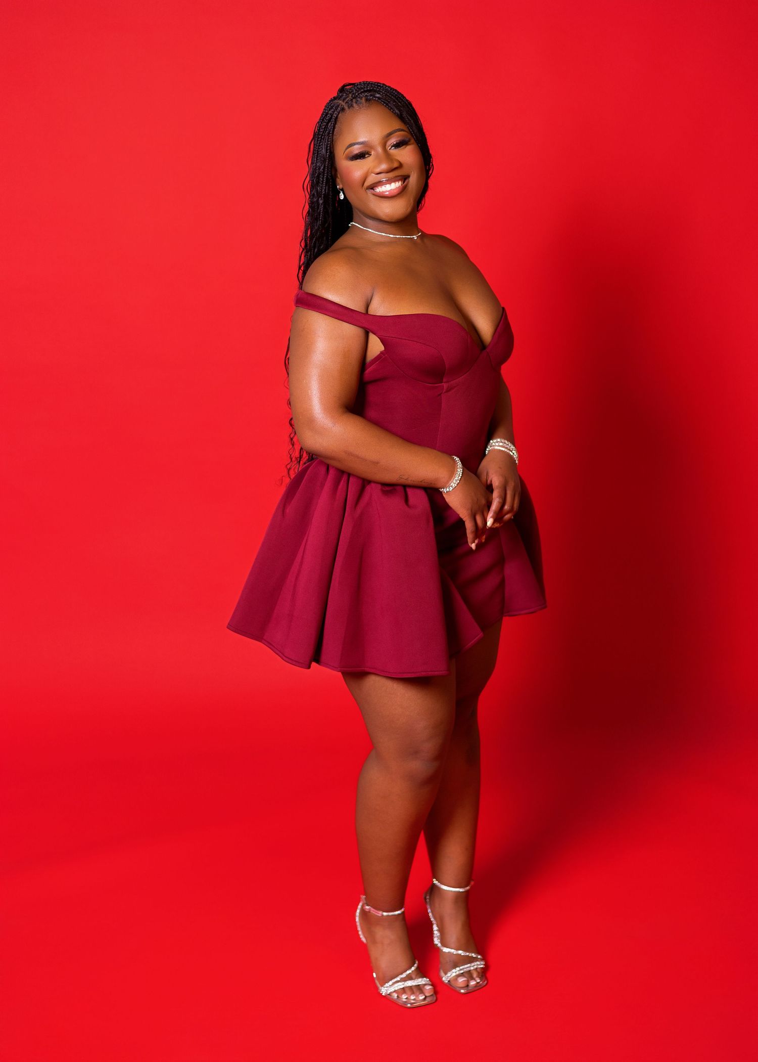 A stylish photo series in burgundy attire against a bright red backdrop featuring confident poses.