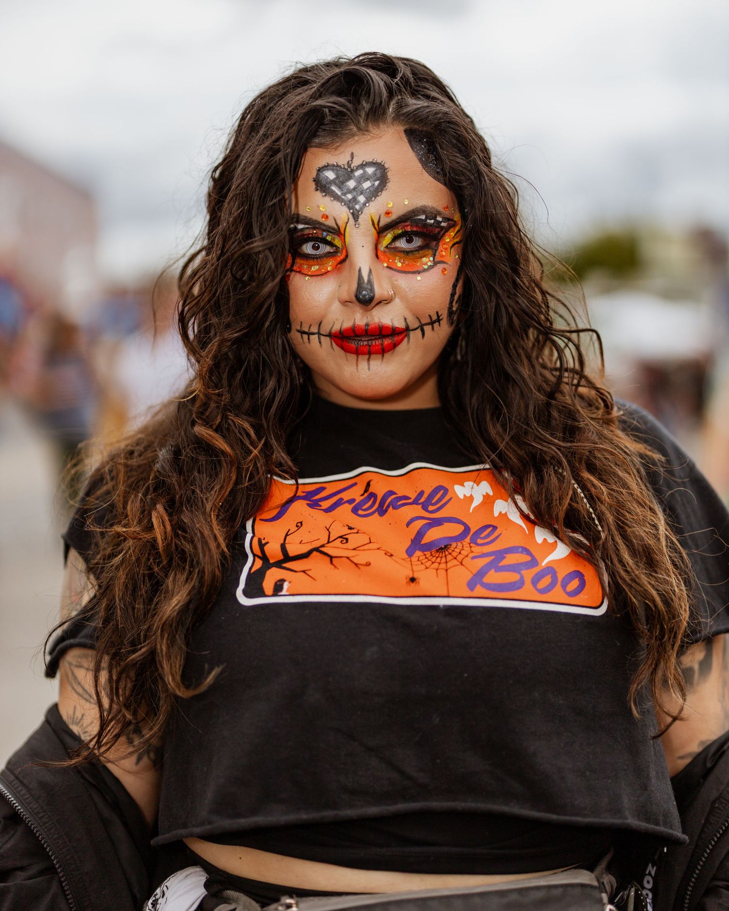A series of close-up shots showing creative Halloween face paint with orange and black designs in a progressive sequence.