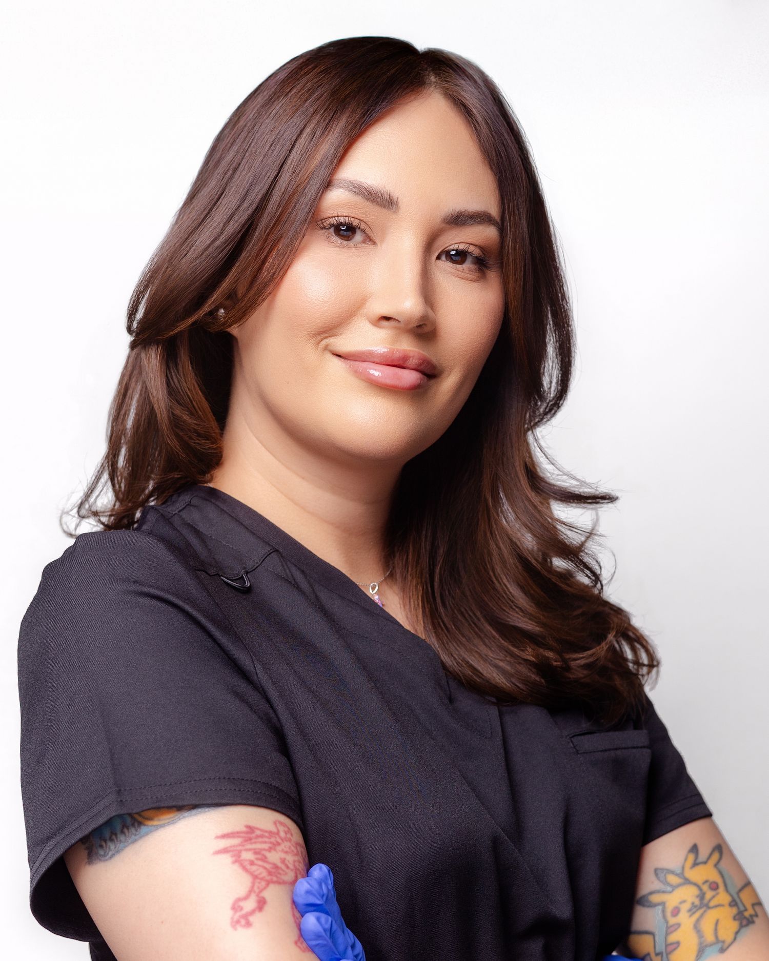 Professional studio portrait of a person in a black top against white background with warm, friendly expression.