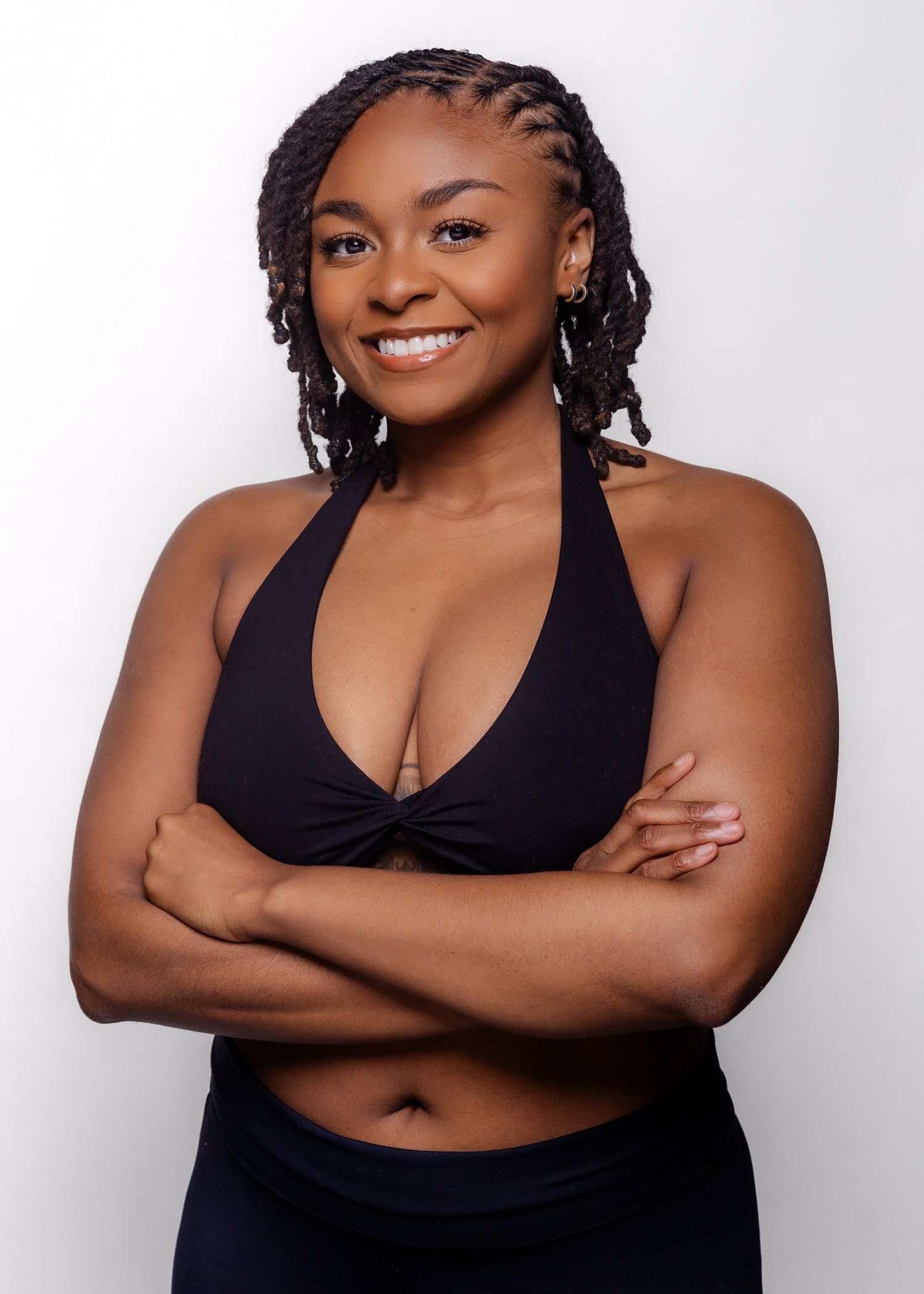 Person in black tank top strikes confident poses against white backdrop.