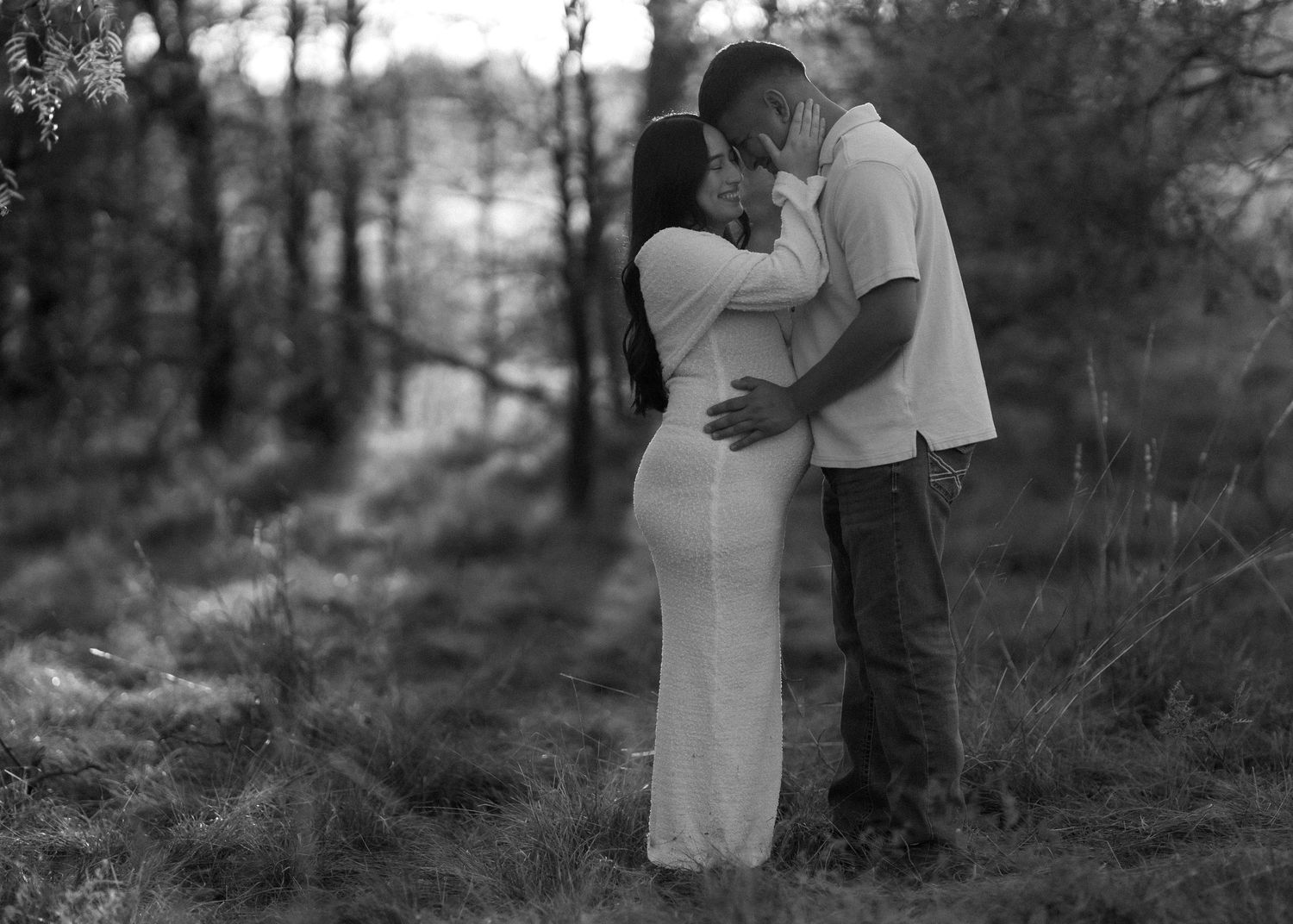 Black and white sequence capturing intimate moments between a couple in a wooded setting.