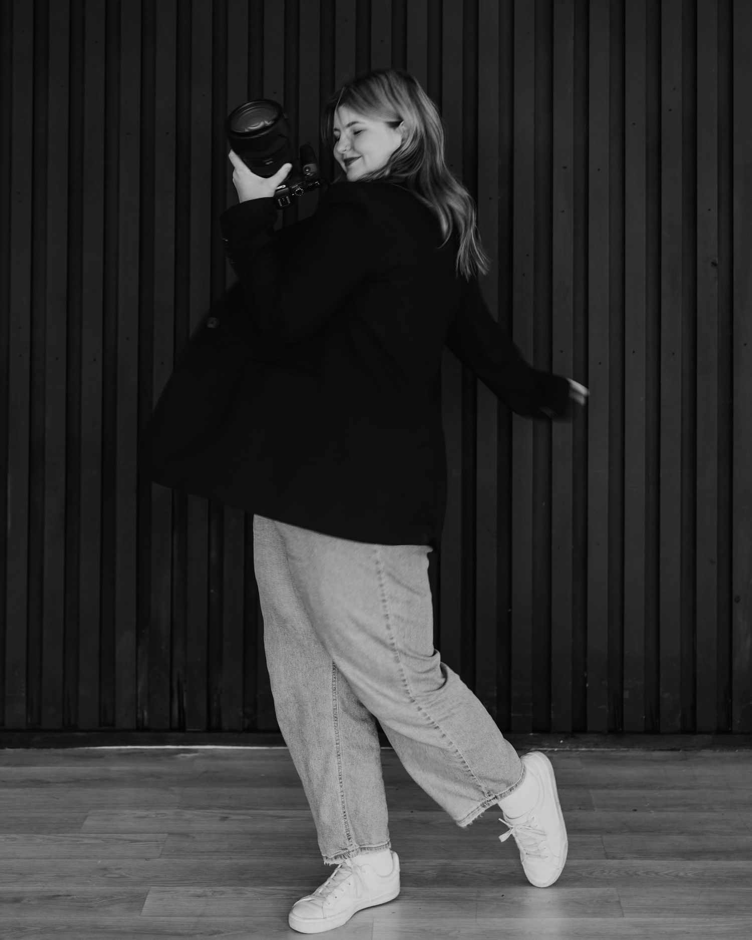 Black and white photo showing dance movements with white sneakers against a striped background.