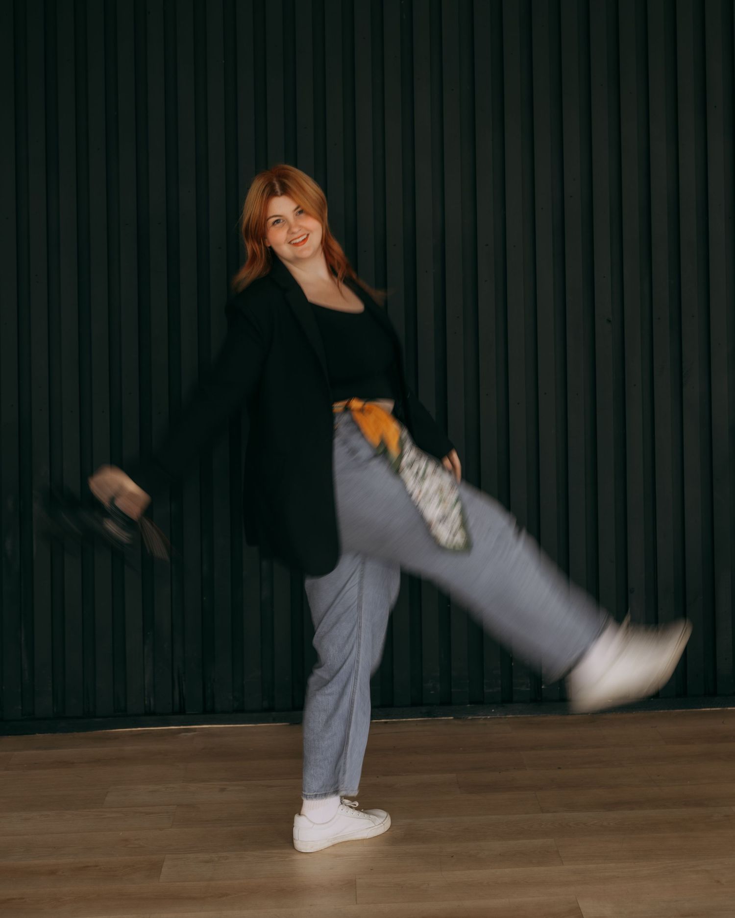 Energetic dance sequence showing spinning movements in casual attire against dark studio setting.