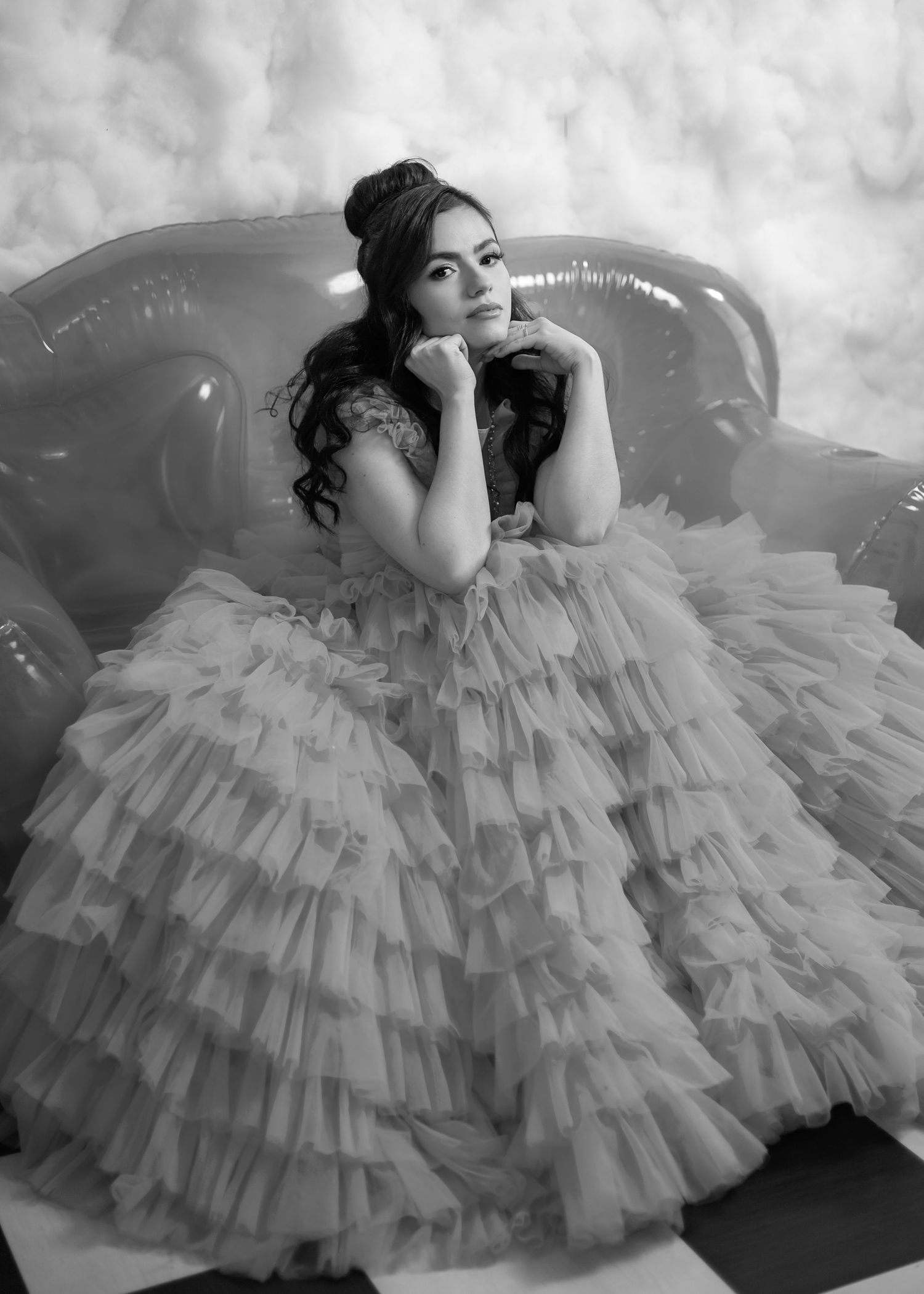 A black and white portrait series shows a person in a dramatic ruffled tulle gown posing gracefully on the floor.