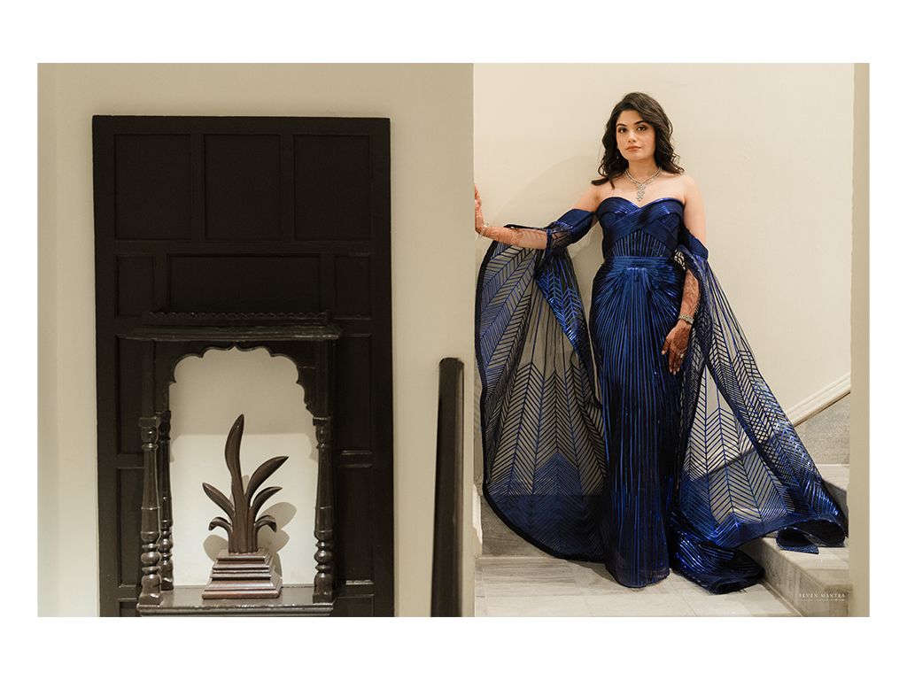 Indian bride poses in stunning royal blue off-shoulder sequin gown with sheer cape overlay.