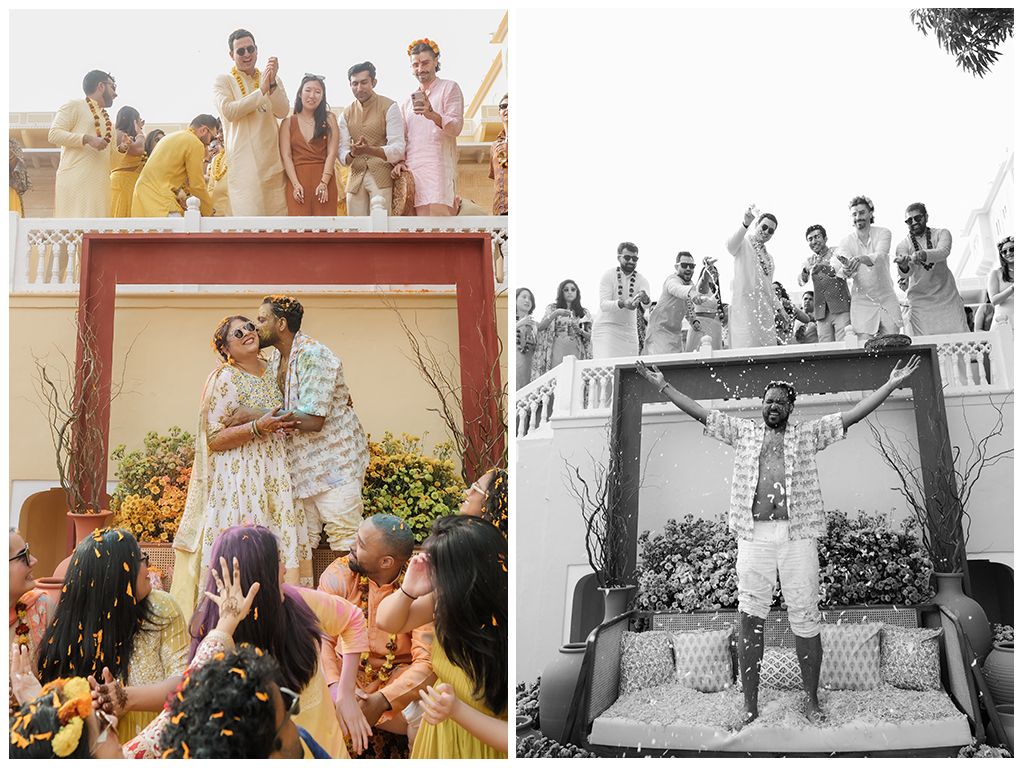 Groom celebrates at haldi ceremony as guests cheer from balcony at Indian palace wedding venue.