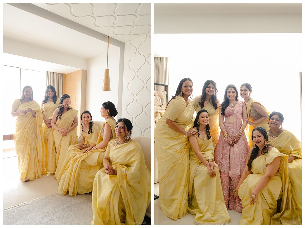 Bridesmaids in matching yellow sarees posing together in bright hotel room before Indian wedding ceremony.