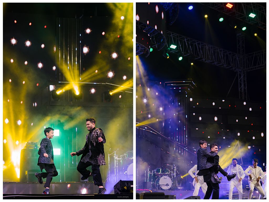 Two performers dancing on a colorful concert stage with dramatic yellow and green lighting effects.