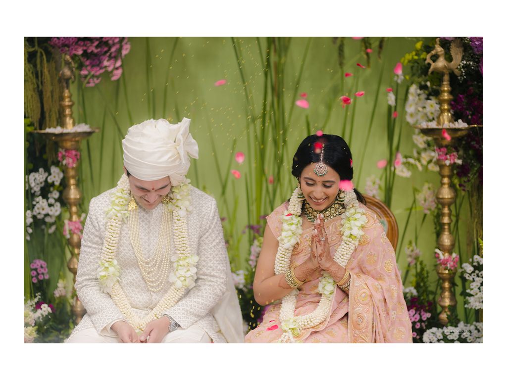 Bride and groom in traditional Indian wedding attire seated during Hindu marriage ceremony.