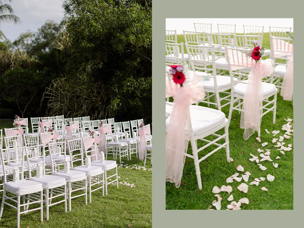 White Chiavari chairs adorned with pink ribbon sashes and rose petals at outdoor wedding.