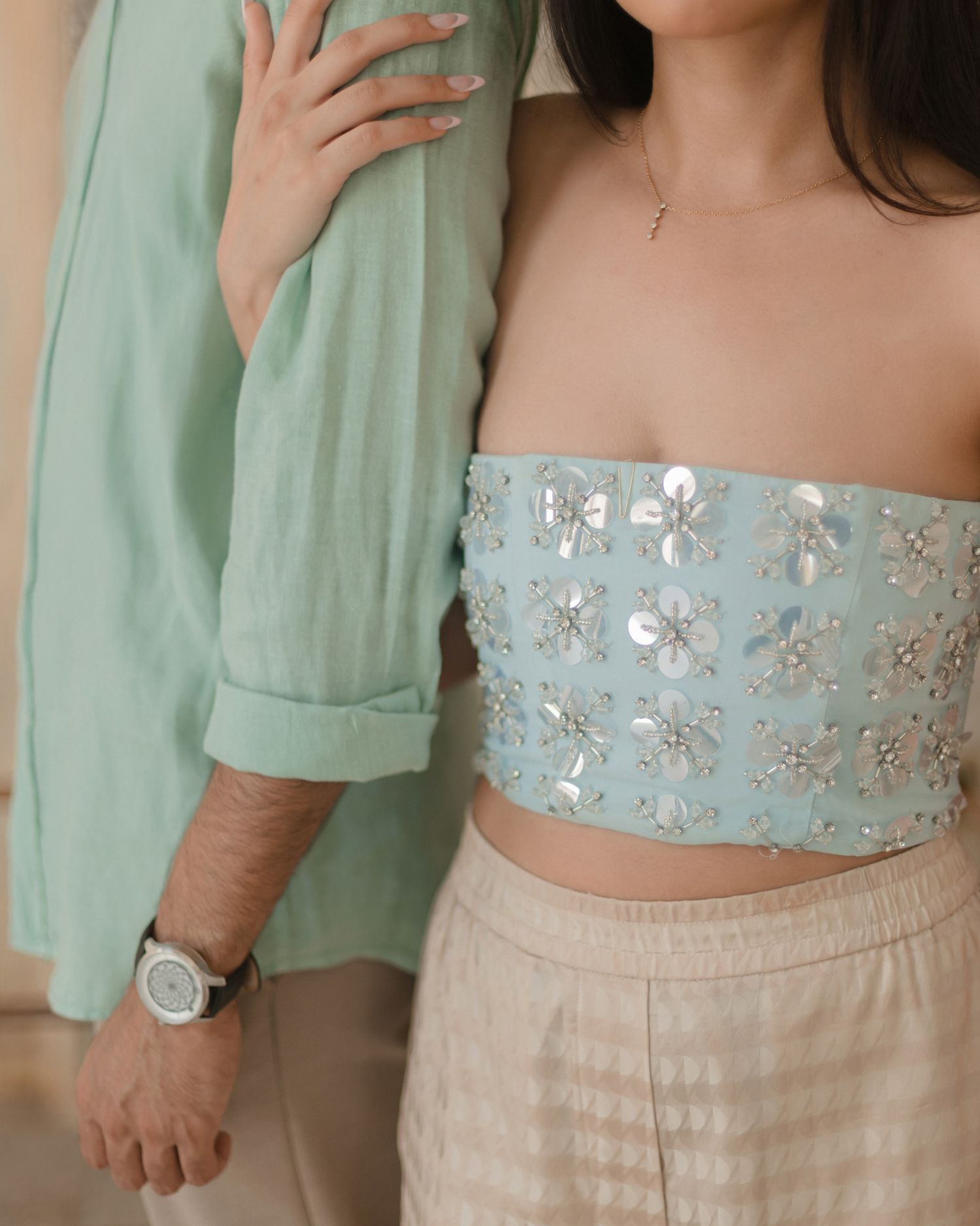 Close-up of embellished blue crop top with floral sequin details at Indian wedding.