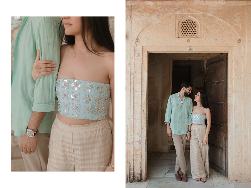Couple in matching mint green and sequined outfits posing at a historic Indian monument.