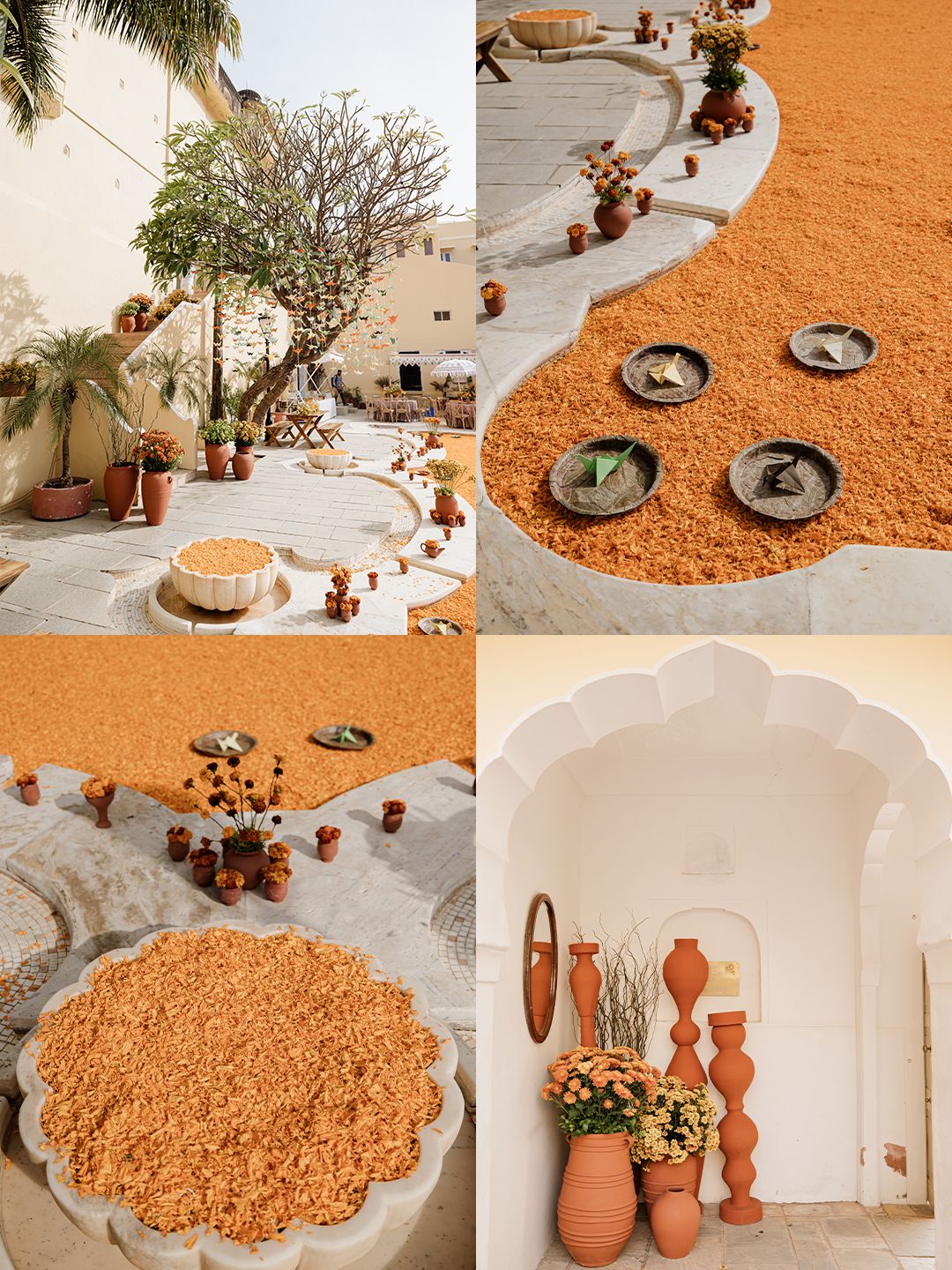 Vibrant orange marigold petal decorations with terracotta pots adorn a traditional Indian wedding venue courtyard.