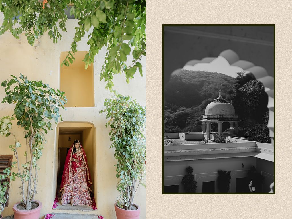 Indian bride in red floral lehenga poses between lush green trees at a royal heritage wedding venue.