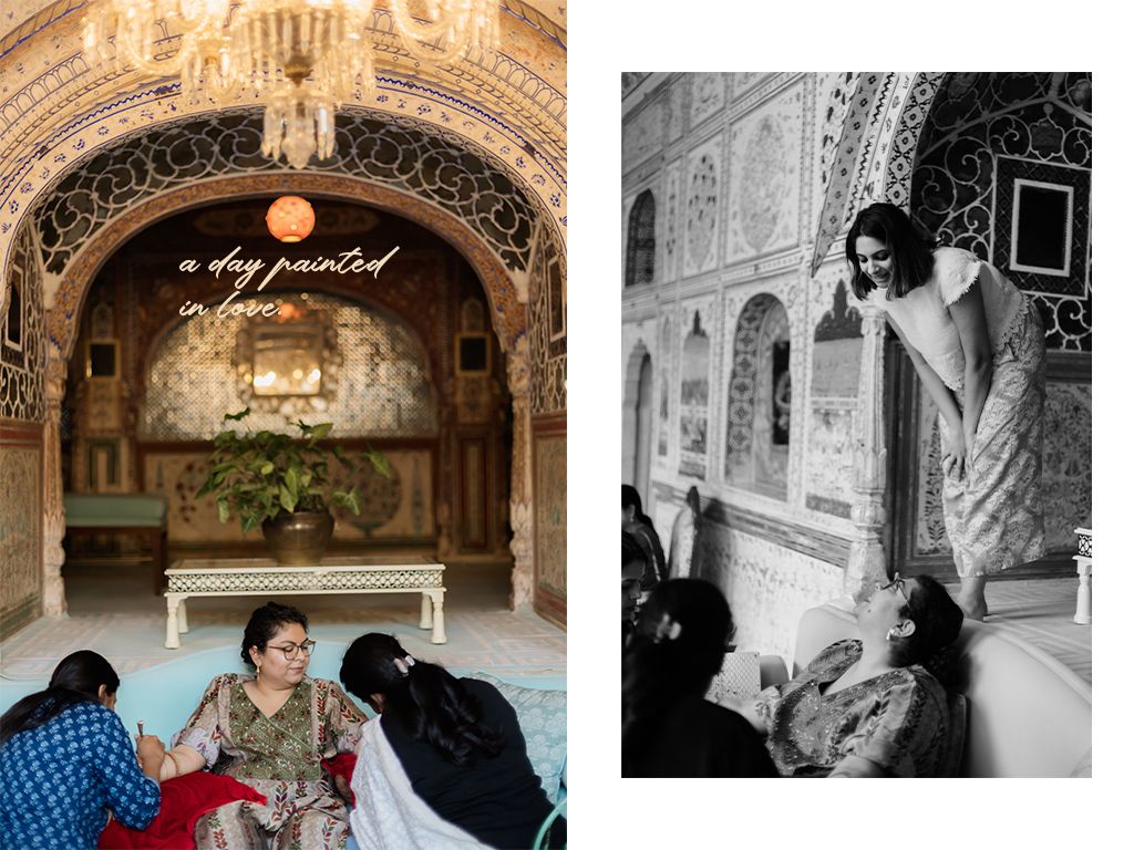 Indian bride gets mehndi applied in ornate palace venue with intricate arched architecture and black white portrait.