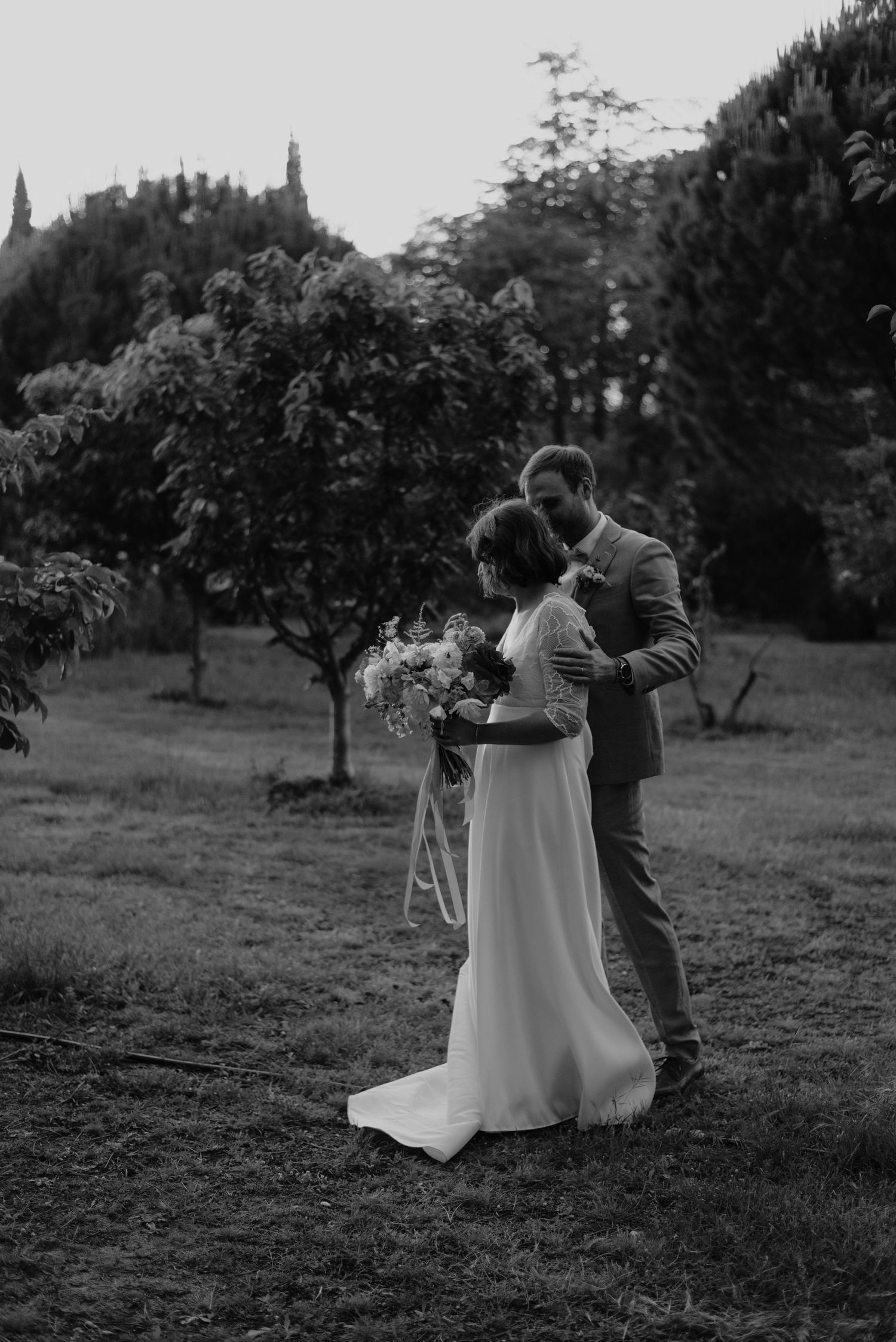 Couple de mariage s’embrassant à la lumière dorée du coucher de soleil
