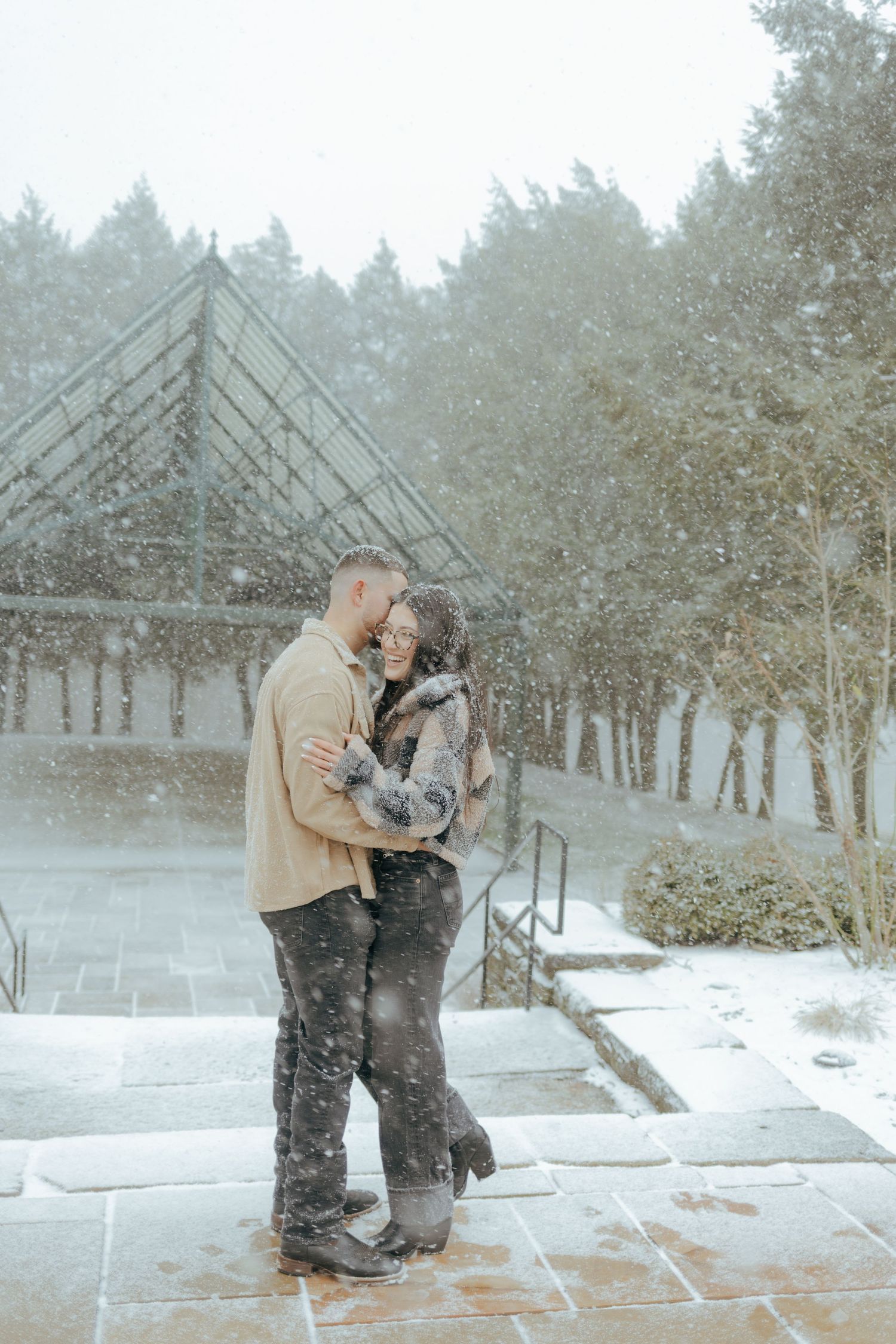 Romantic couple embracing in heavy snowfall outdoors at Hartwood Acres in Pittsburgh