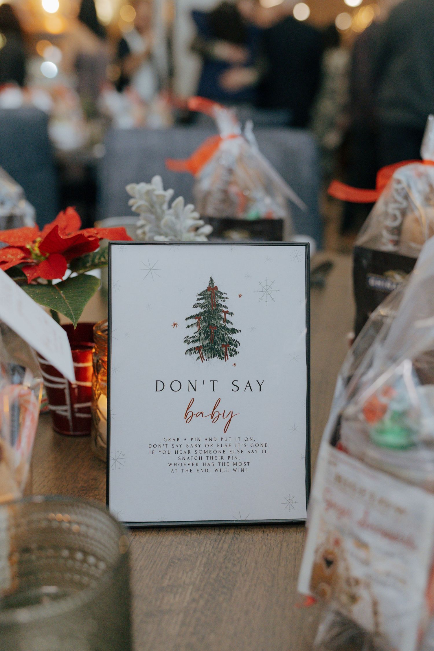 Christmas baby shower table decoration featuring Don't Say Baby game sign with festive holiday tree design.