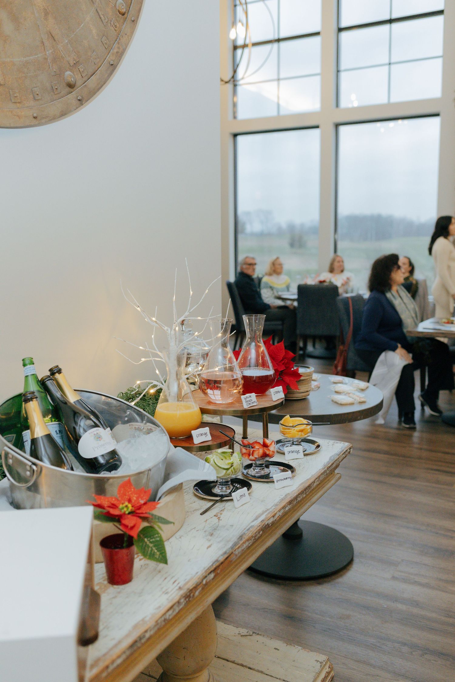Elegant brunch setup with champagne, mimosas, and appetizers in bright airy venue with guests at a baby shower in Pittsburgh