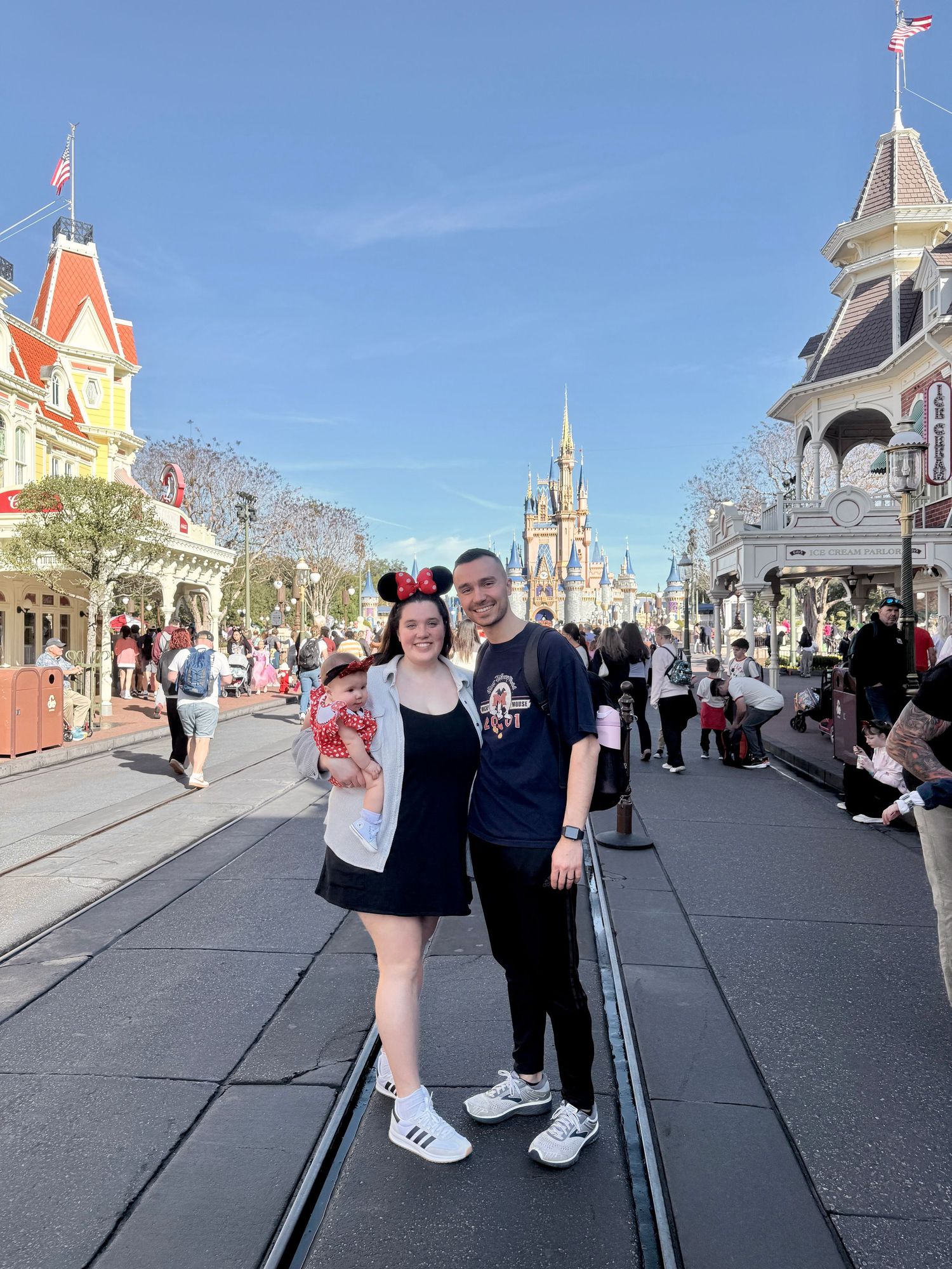 Couple posing on Main Street USA at Magic Kingdom with Cinderella Castle in background.