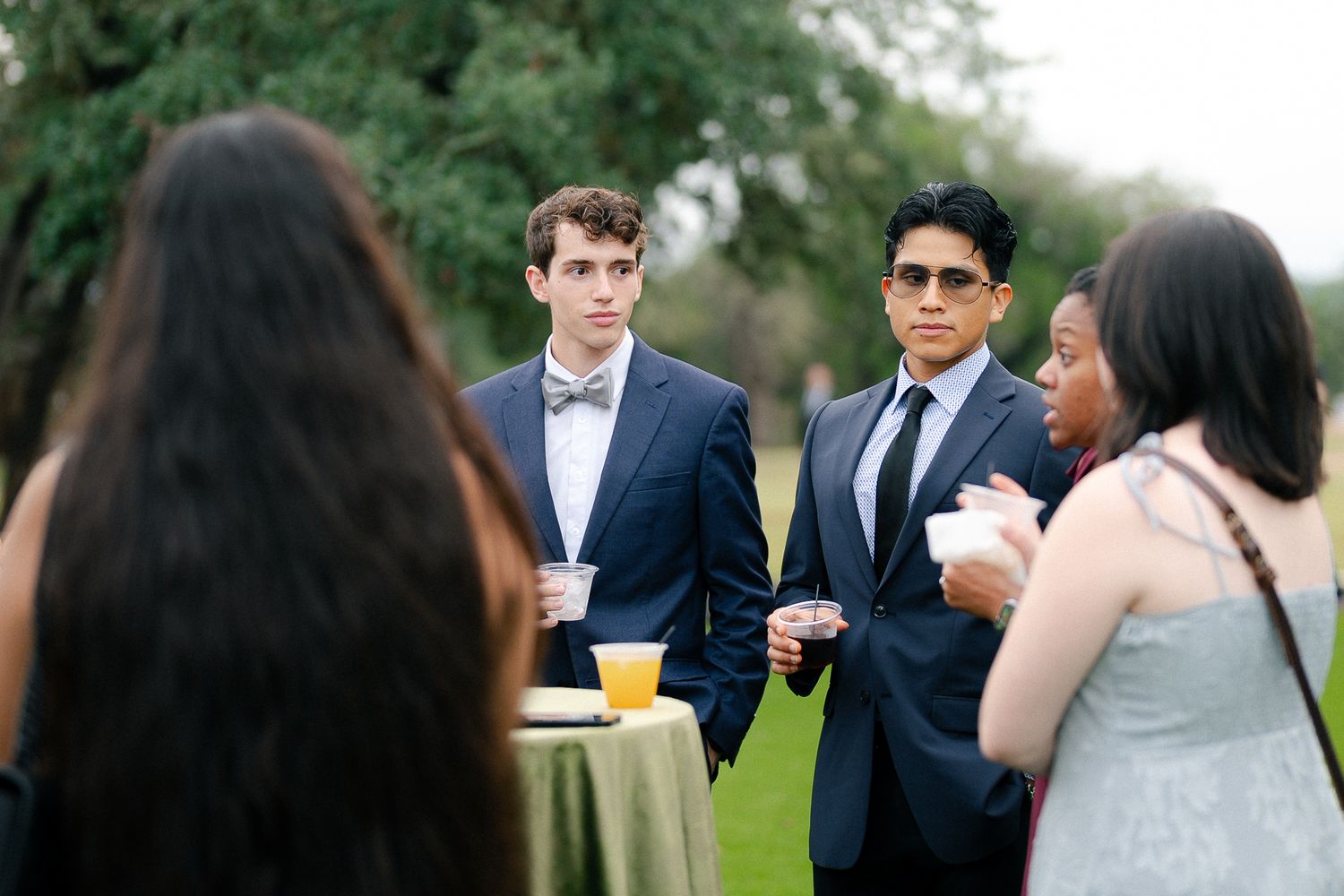 Wedding guests enjoying outdoor cocktail hour at an elegant garden reception.