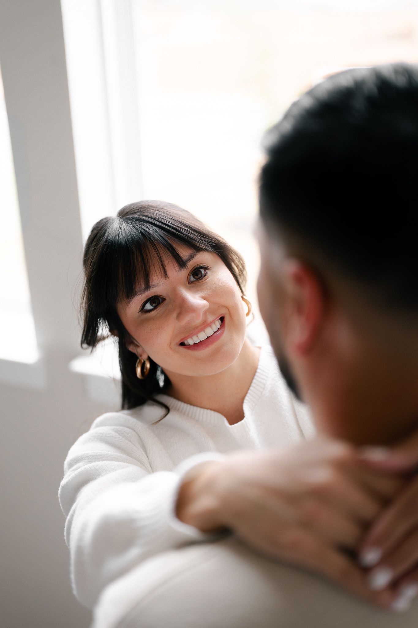 A series of romantic engagement photos showing a couple in white sharing intimate moments against a bright background.